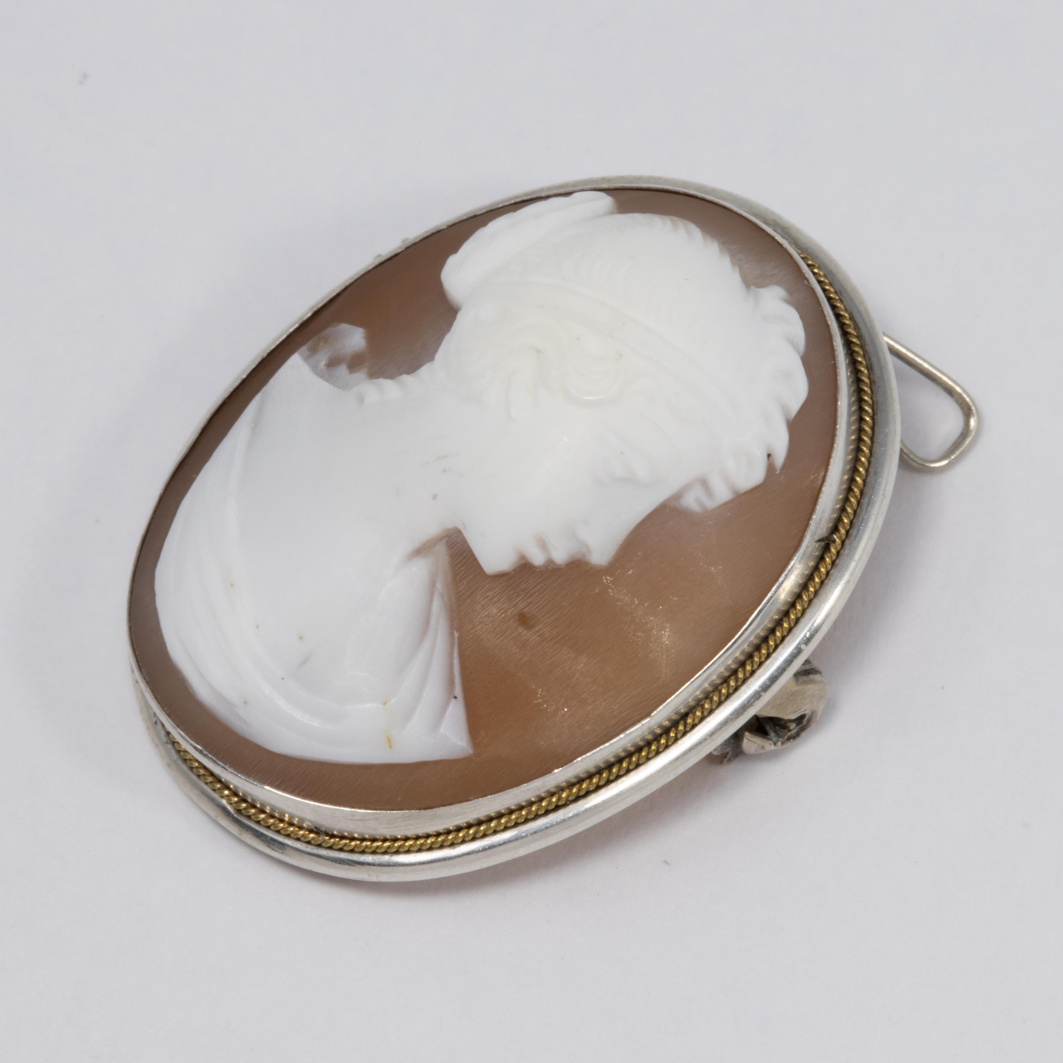 An exquisite cameo pin/brooch/pendant accessory. Features a two-tone cameo with a Victorian female figure, set in a sterling silver, open back bezel.

Unidentified hallmark on the pin stem.
