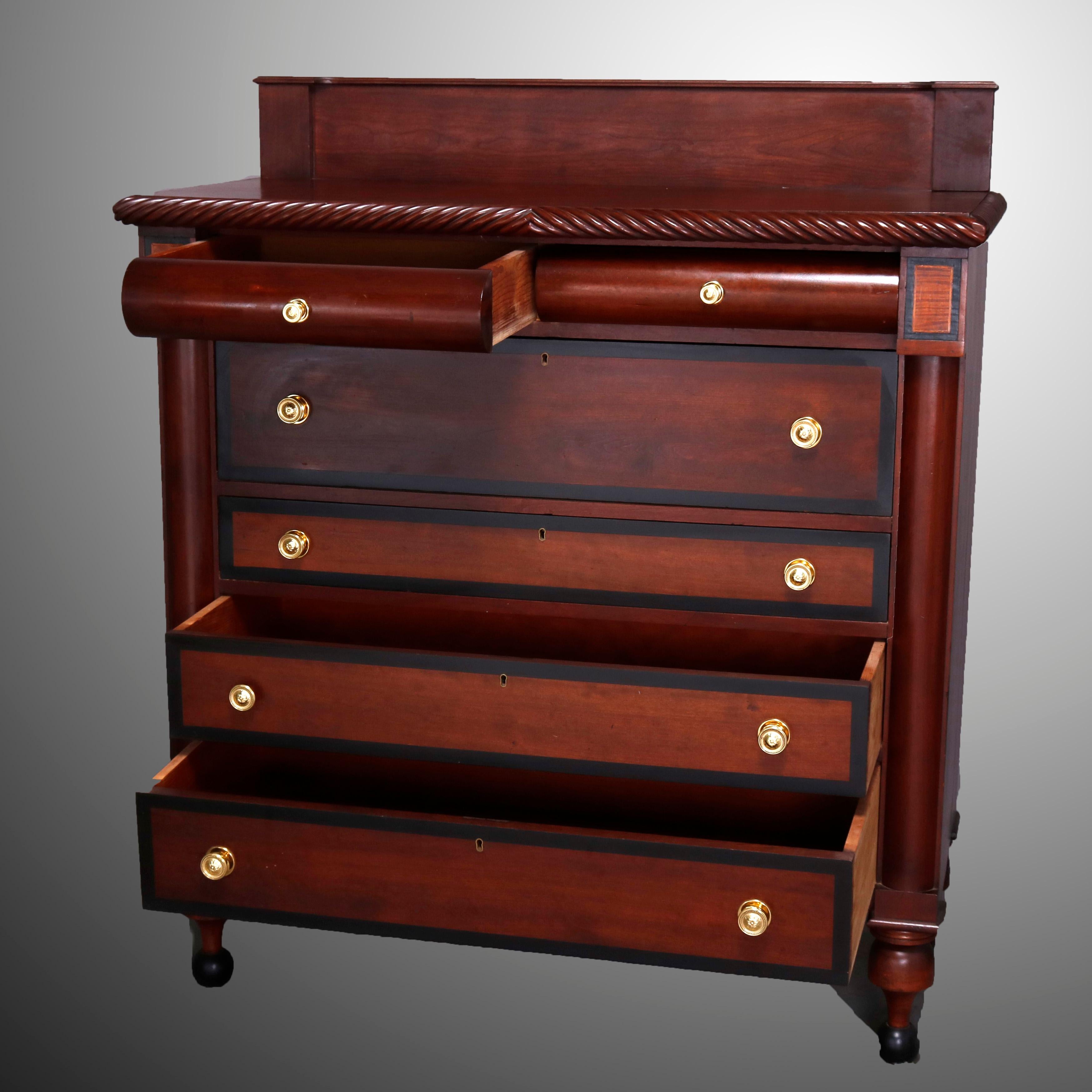 An antique Sheraton chest of drawers offers mahogany construction with top having backsplash and carved gadrooned bordering surmounting case with double bow front drawers over deep frieze drawer and three graduated and banded long drawers flanked by