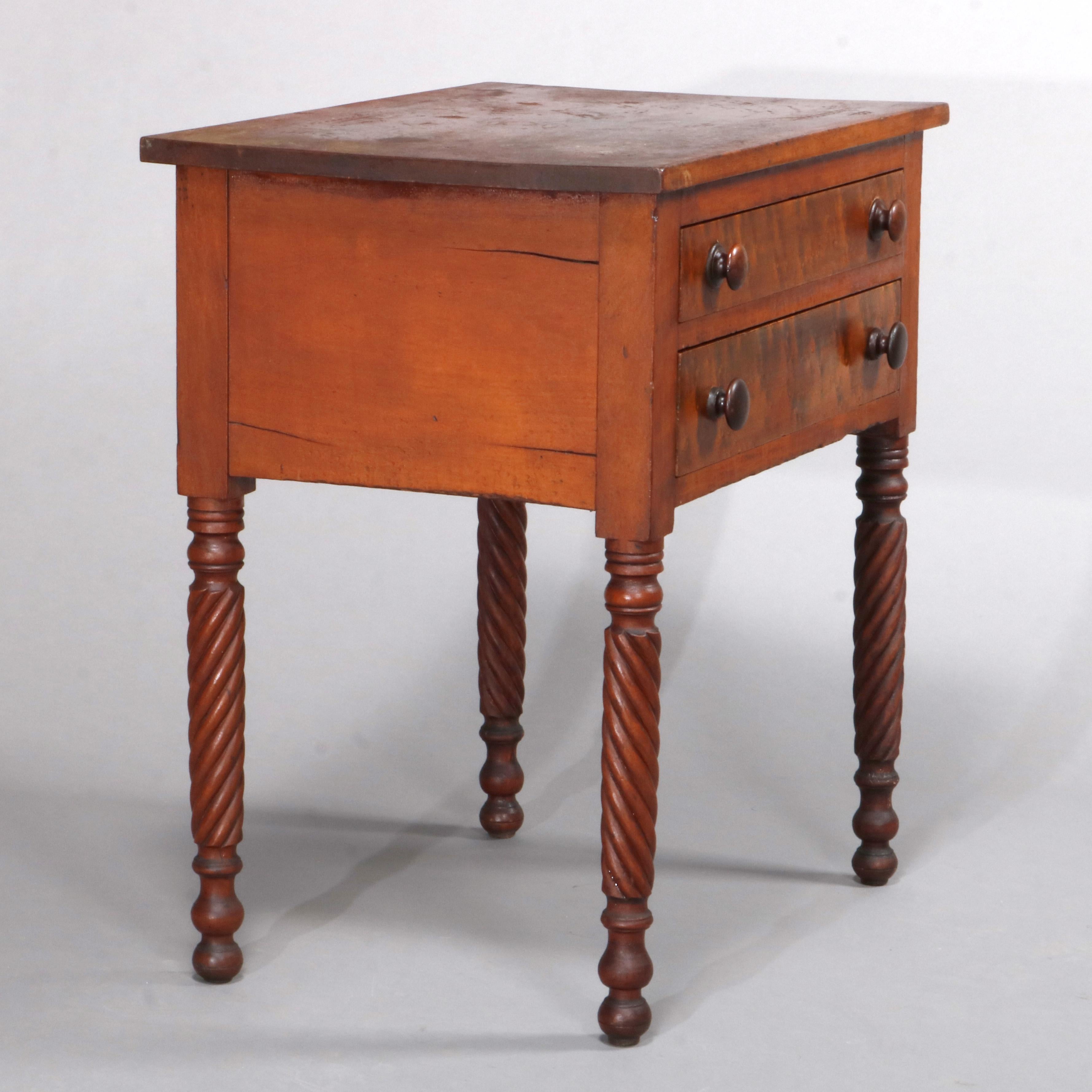 An antique Sheraton side stand offers cherry construction with case having two bird's-eye maple drawers, raised on turned legs, circa 1840

Measures: 28.25
