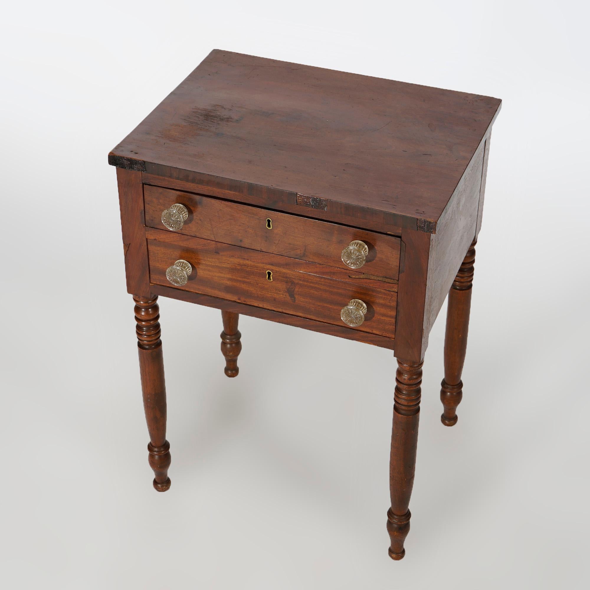 Ann antique Sheraton side stand offers cherry and mahogany construction with case having two drawers (one divided) and raised on turned legs, 19th century

Measures- 29''H x 21''W x 17.25''D.