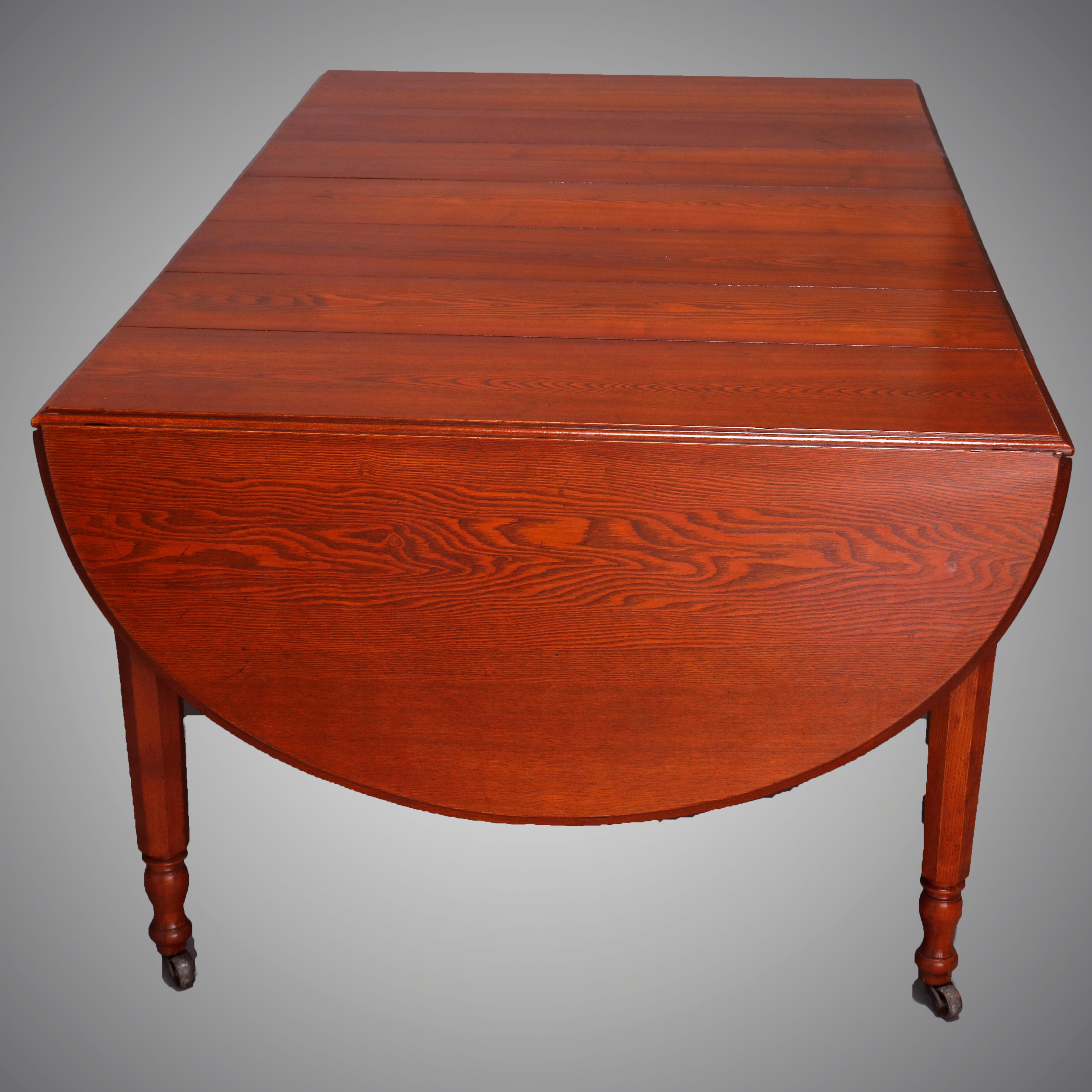 An antique Sheraton drop leaf banquet table offers chestnut construction with round top raised on turned legs with casters and expends to accept five leaves, circa 1910

***DELIVERY NOTICE – Due to COVID-19 we have employed LIMITED-TO-NO-CONTACT