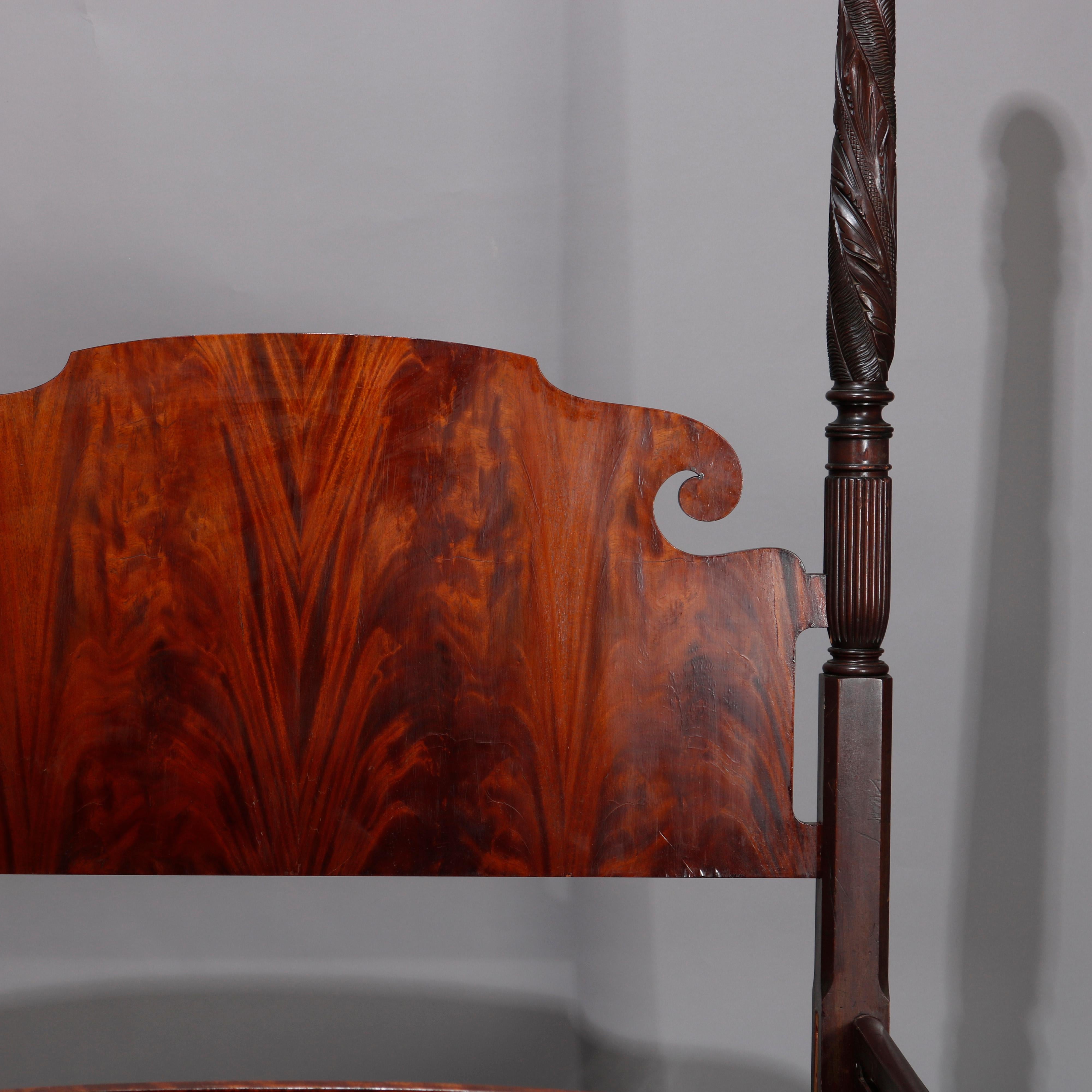 An antique Sheraton full/double poster bed offers flame mahogany construction with scroll form headboard, shaped footboard, with four carved foliate acanthus carved posts, 19th century

Measures: 94