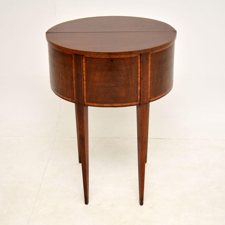 A lovely and extremely unusual antique side table made from mahogany and satin wood inlay. This is in the Sheraton style, we are not quite sure if it is Edwardian (c.1900) or Georgian Period (c.1800). It is hard to tell as it is quite a unique