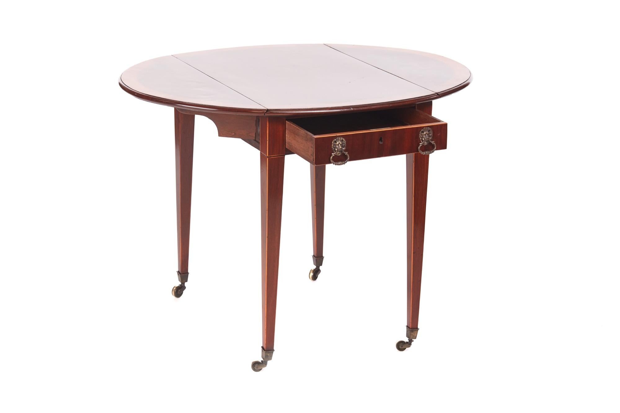 Antique Sheraton period inlaid mahogany pembroke table which has a quality mahogany top crossbanded in satinwood, two oval drop leaves, one drawer and one dummy drawer to the frieze with original brass handles. It stands on four square tapering legs