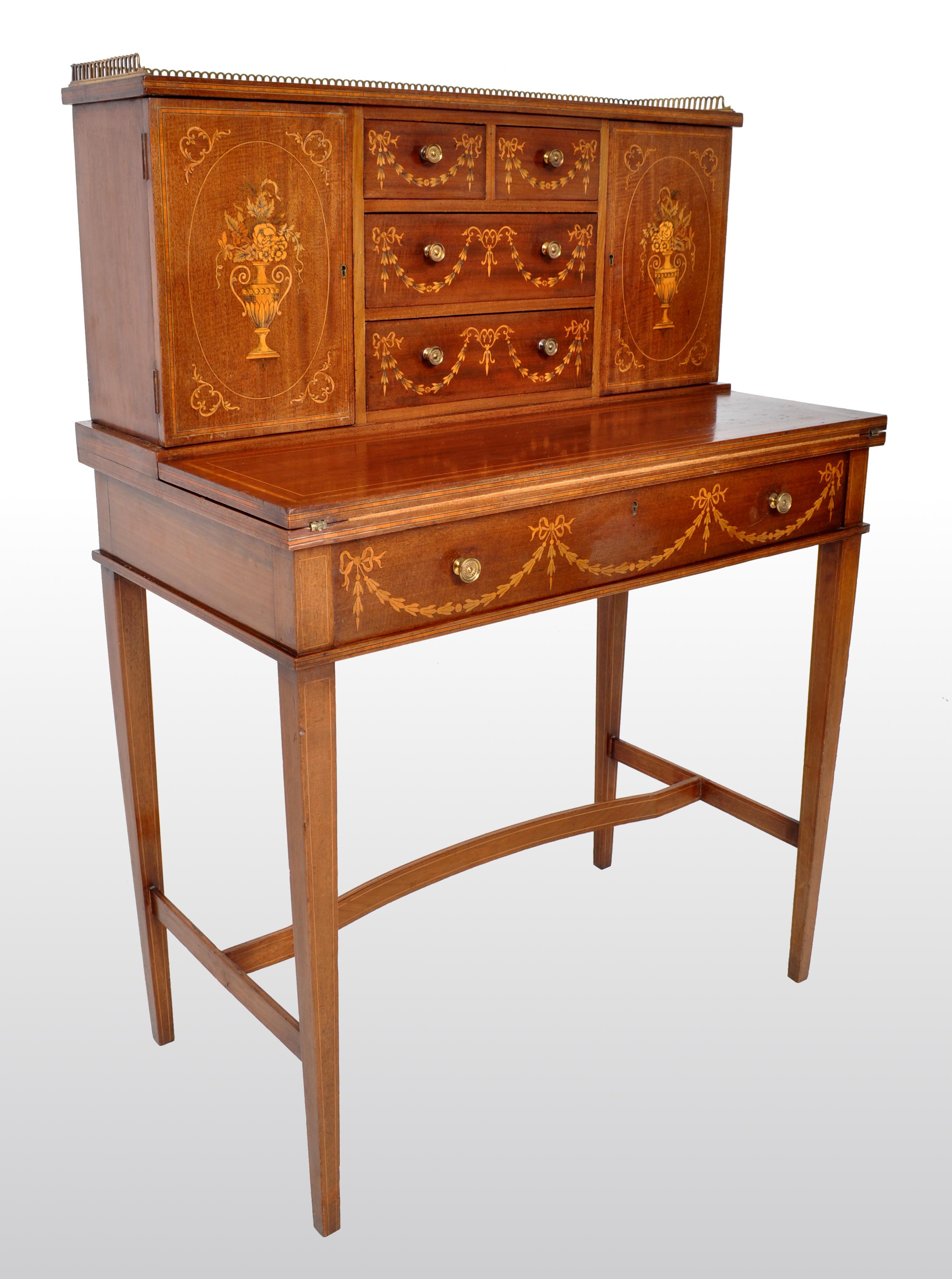 Antique Sheraton Revival inlaid mahogany desk / Bonheur du Jour / writing table, circa 1895. The desk having a pierced brass gallery to the top, below a pair of doors finely inlaid with neoclassical flowering urns. The doors enclosing lateral and