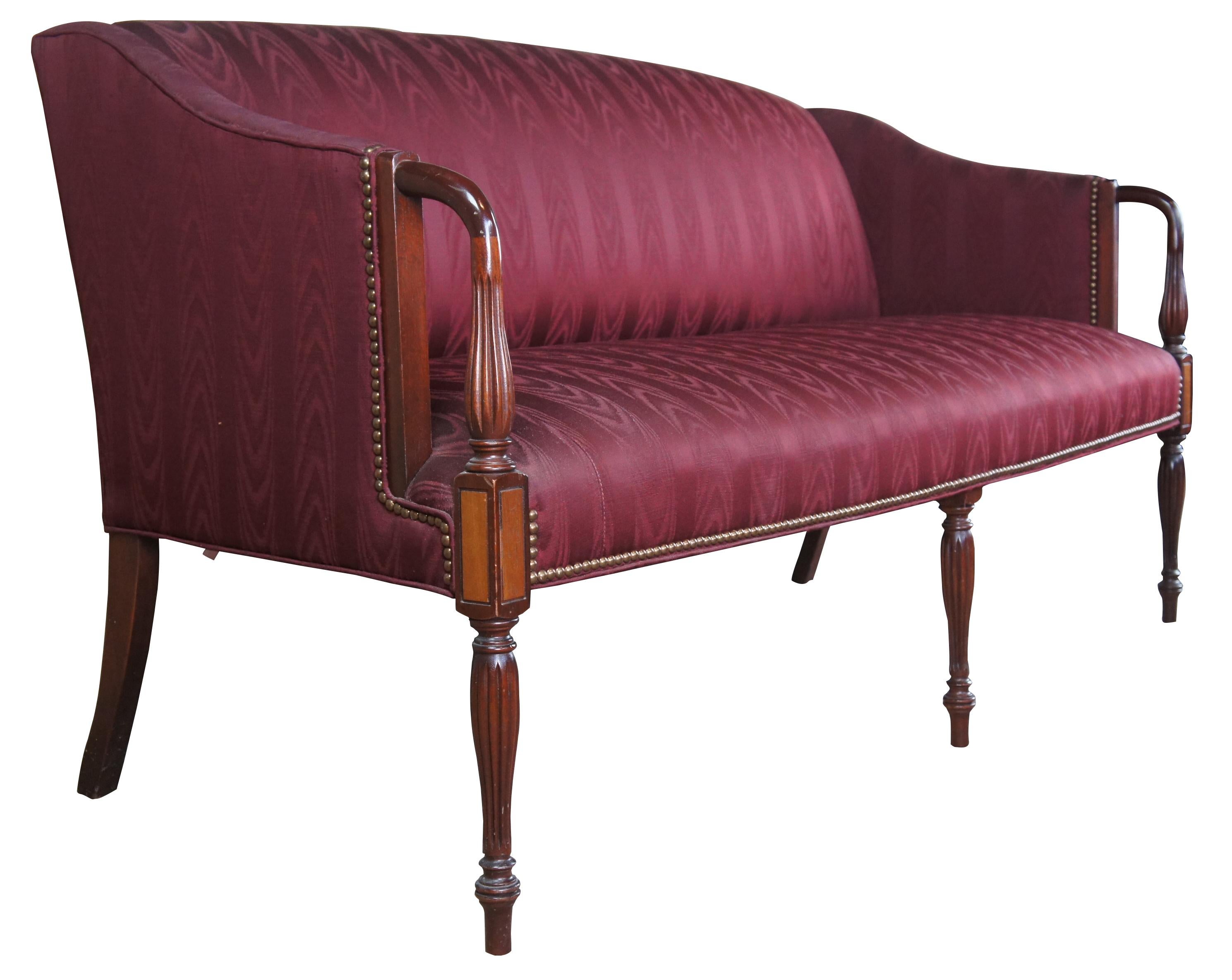Antique Sheraton style bow back parlor sofa or settee. Made of mahogany featuring an arched back with red silk upholstery, nailhead trim, and ornate turned and reeded legs with arrow feet. Includes smooth open arms leading to elegantly banded