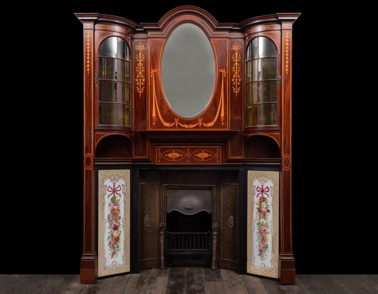An outstanding antique Sheraton revival wooden fireplace with original hand painted Dolton Lambeth panels and copper insert.
Constructed using the finest figured dark wood with satinwood, boxwood and fruitwood neo-classical style inlays. The glazed