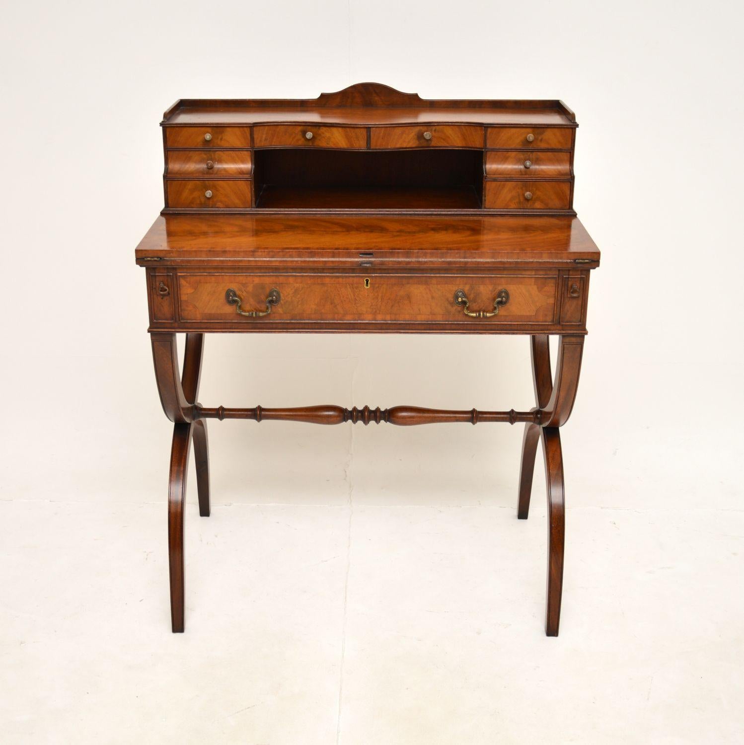 A wonderful antique Sheraton style escritoire desk. This was made in England, it dates from around 1900-1910.

The quality is outstanding, this is very well made and beautifully designed. It sits on a X frames with a nicely turned stretcher for