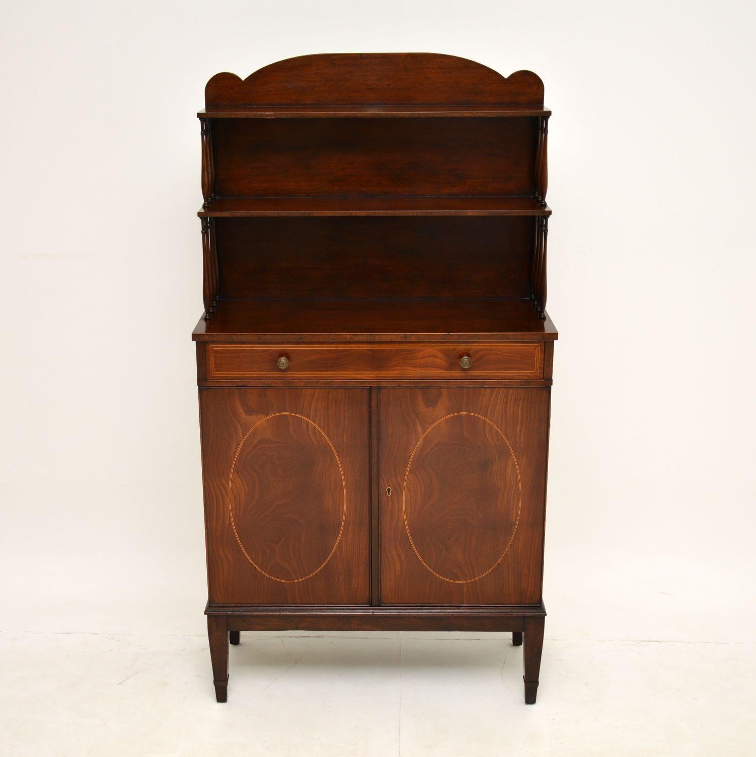 A smart and extremely well made antique Sheraton style bookcase over cabinet, which I would date to around the 1920-30’s period.

The design is fantastic, with an open bookshelf on top, central drawer and locking lower cabinet. There is fine satin