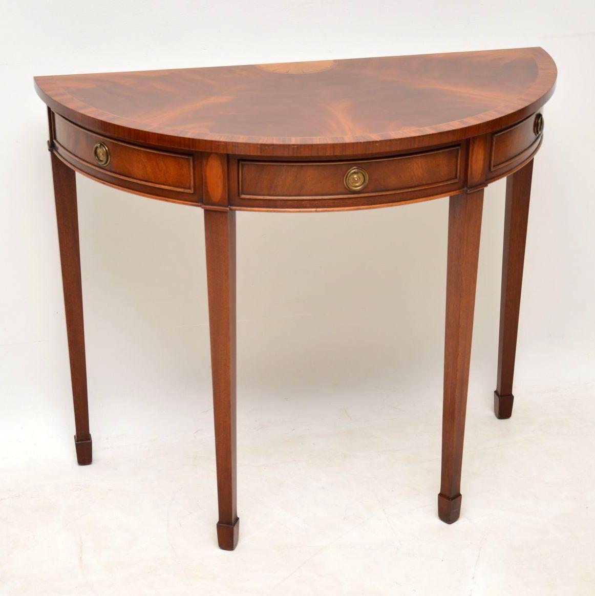 Elegant antique inlaid mahogany console table in excellent condition and having just been French polished. The top is made up of segmented flame mahogany veneers, with a satinwood inlaid design and cross banding in rosewood or Kingwood which extends