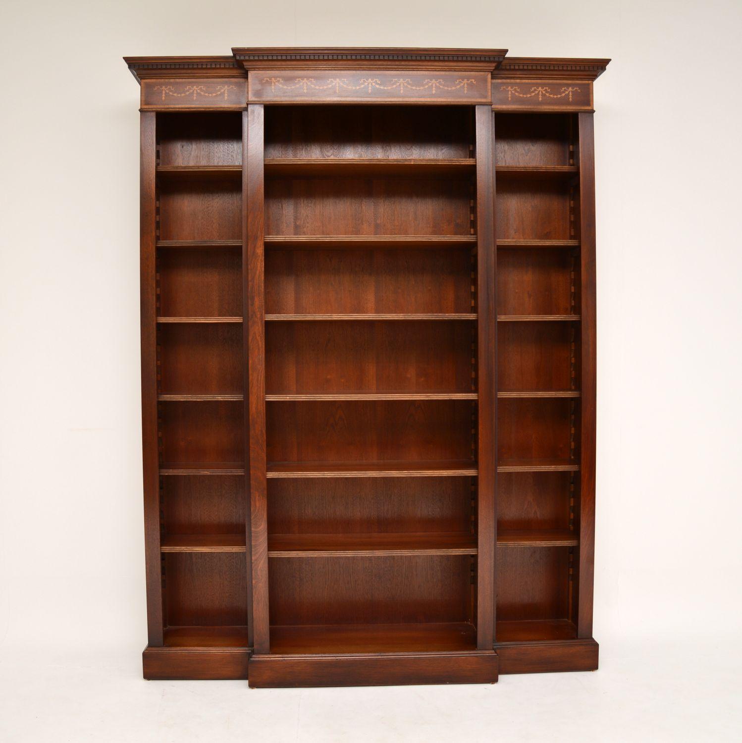 A large and impressive inlaid mahogany breakfront bookcase, in the antique Sheraton style. This dates from circa 1950s period and it is of superb quality.

It is large and heavy, yet retains an refined and elegant look. This is beautifully made