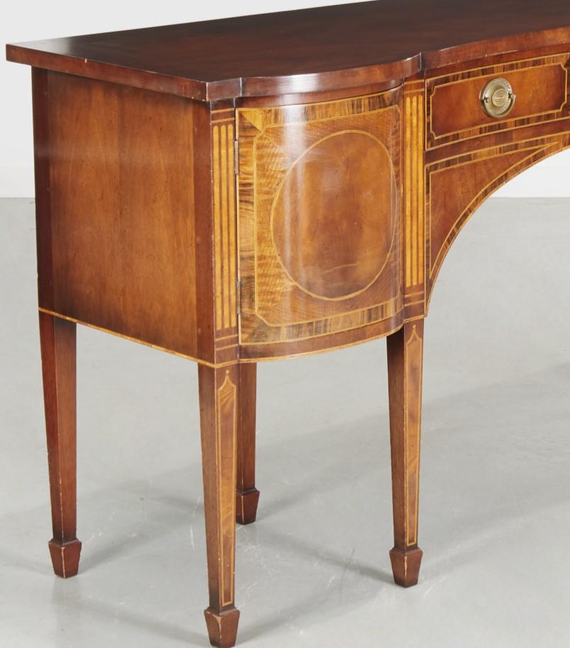Late 19th / early 20th century, superbly crafted mahogany sideboard with a sinuously curved central drawer with brass handles, flanked by two bow front cabinets. The sideboard is crossbanded with satinwood and tulipwood and inlaid with chequer