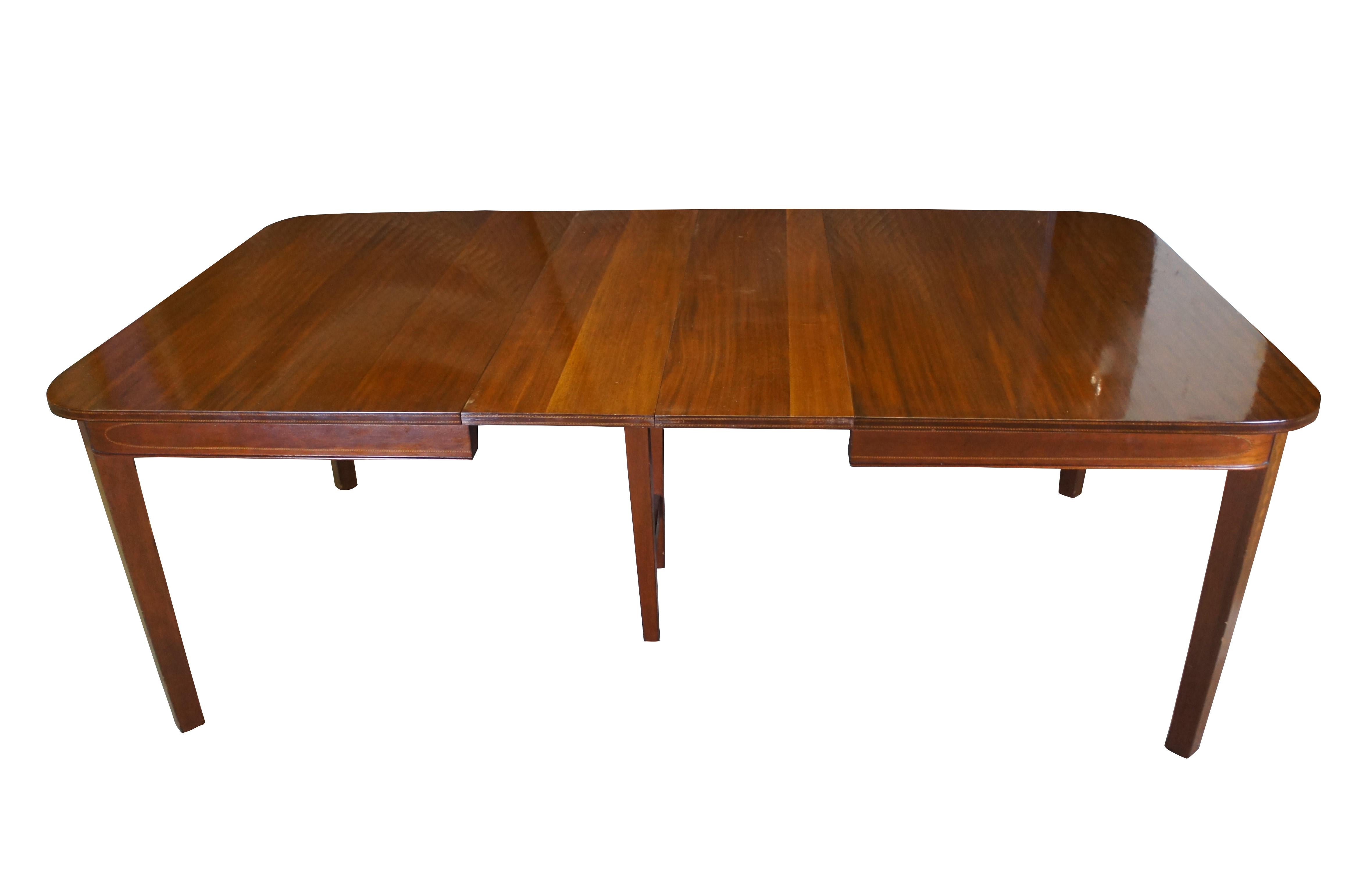 Table de salle à manger ancienne en acajou de style Sheraton, de forme rectangulaire, aux angles arrondis, avec deux allonges, décorée de fleurs de tulipes incrustées dans un motif ascendant le long des pieds et de bandes sur le bord de la table et