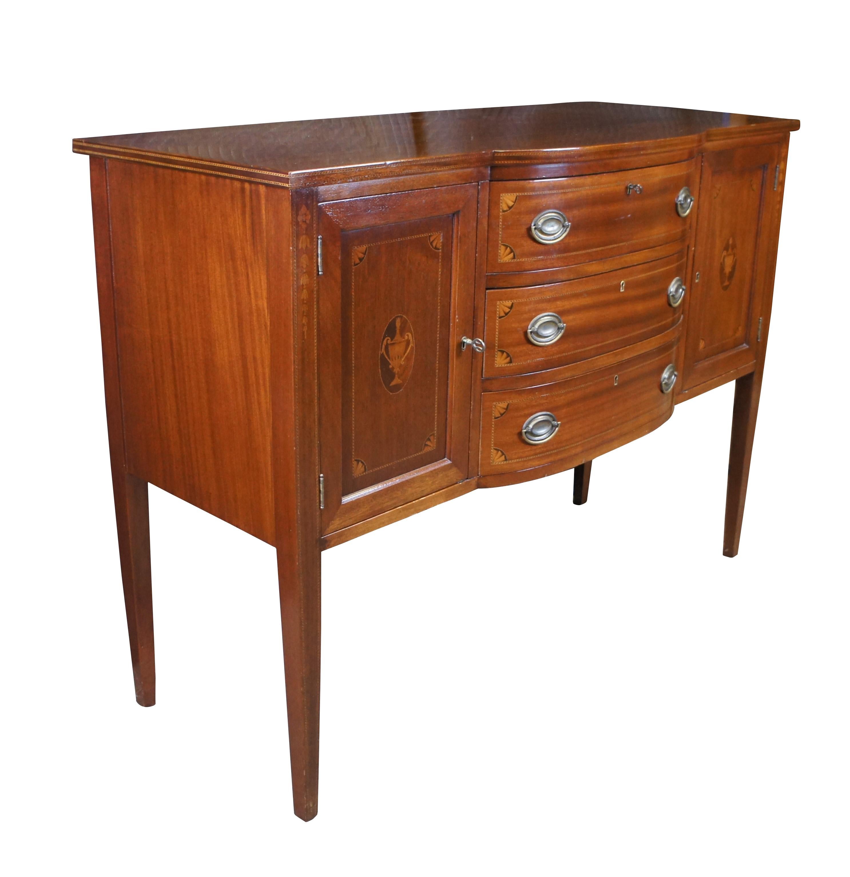 Antico buffet, credenza o consolle.  Realizzato in mogano in stile Sheraton, presenta tre cassetti demilune con fronte ad arco, la cui parte superiore è divisa e foderata con velluto blu; è affiancato da due armadietti, ognuno dei quali è decorato