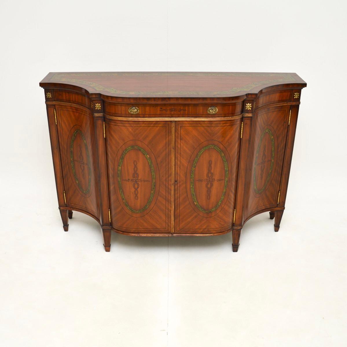 Una splendida credenza antica in legno satinato dipinto in stile Sheraton. Questo modello è stato realizzato in Inghilterra e risale probabilmente agli anni '50.

La qualità è eccezionale, è estremamente ben fatta con splendidi motivi di venatura