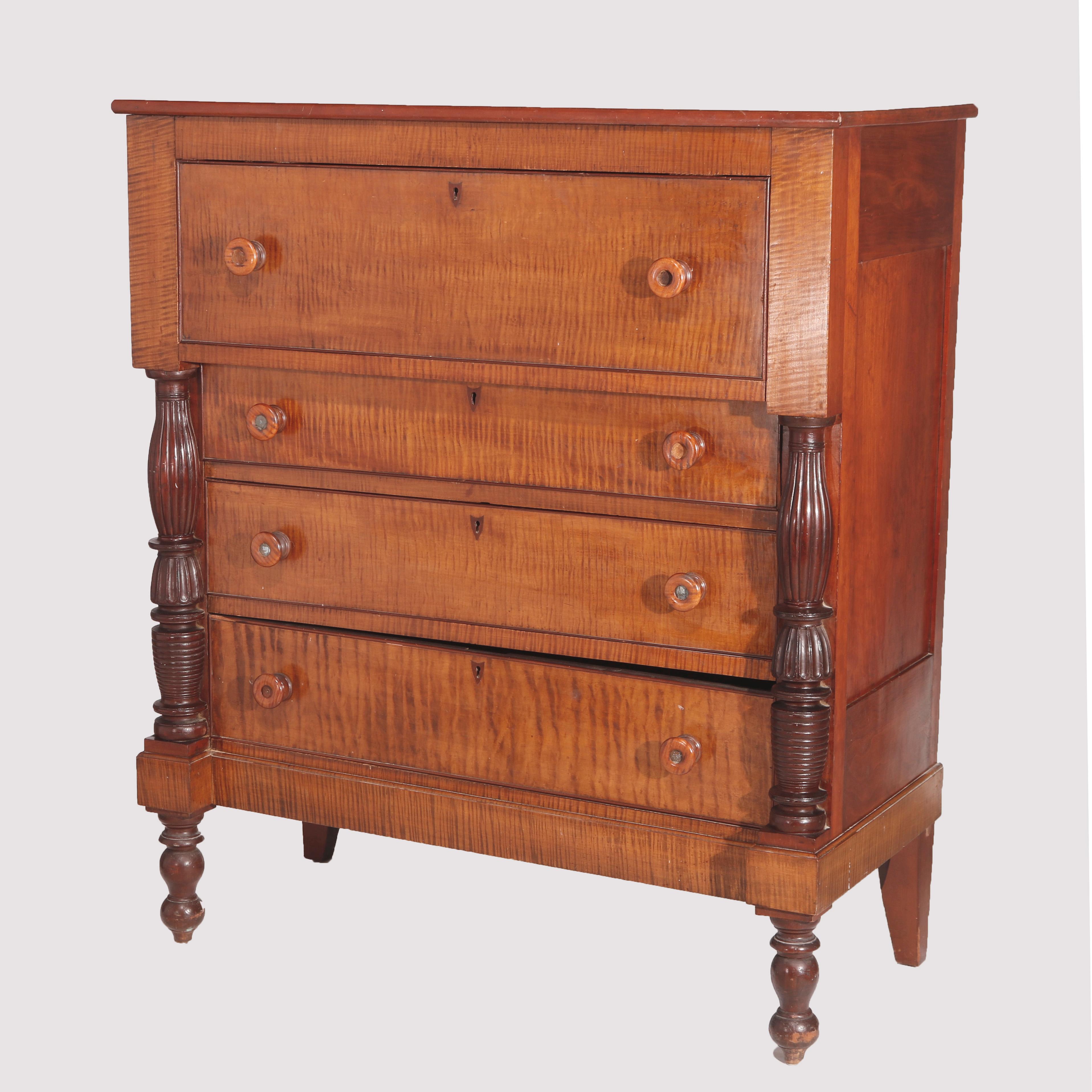 An antique Sheraton chest offers tiger maple construction with upper deep drawer over four long drawers having flanking reeded columns, inlaid cherry escutcheons, raised on turned feet, circa 1840.

Measures - 50.5
