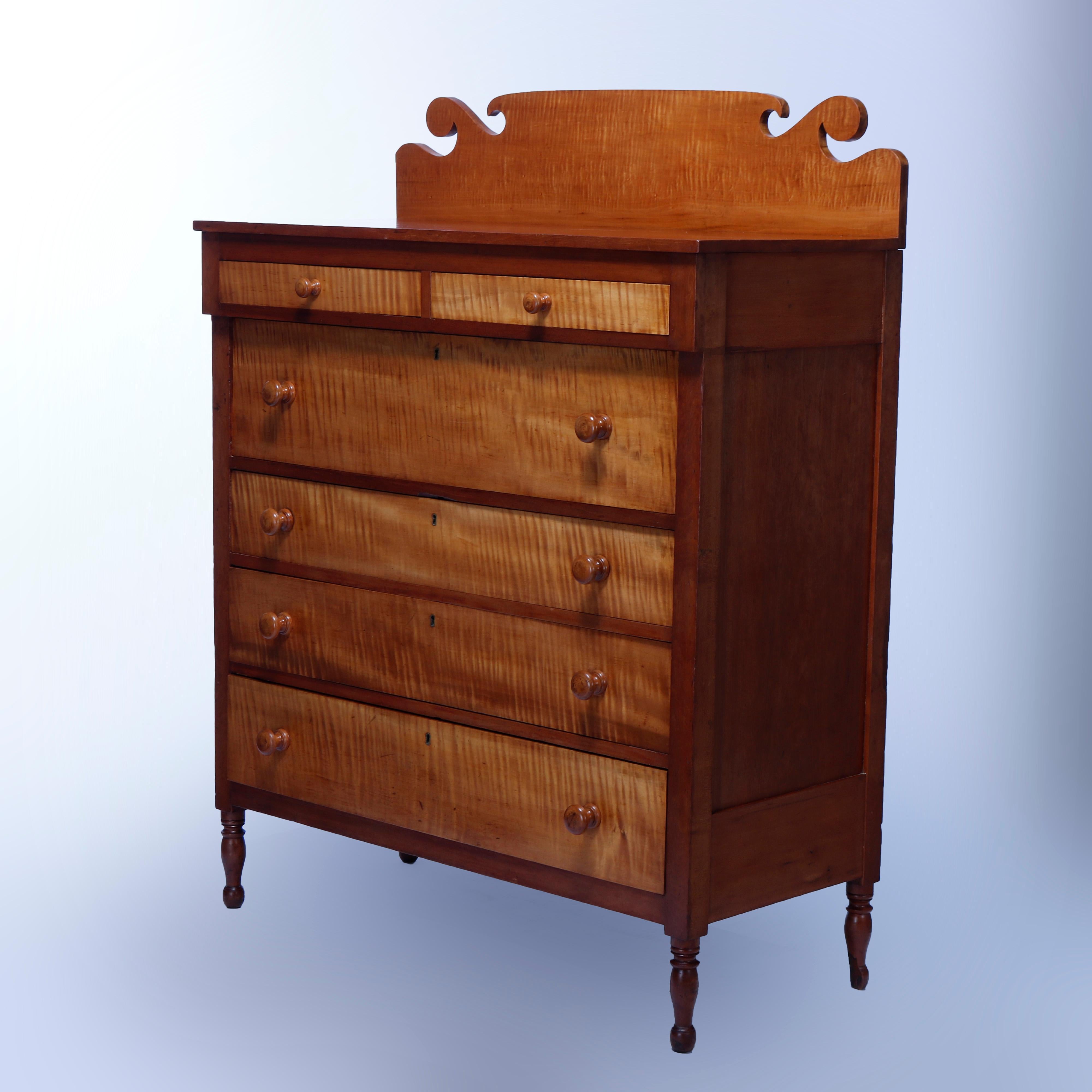 An antique Sheraton tall chest offers shaped backsplash over cherry case having birds eye maple drawers, two small over one deep surmounting three graduated, raised on turned legs, c1830

Measures - 59.25'' H x 46.5'' W x 21.25'' D.