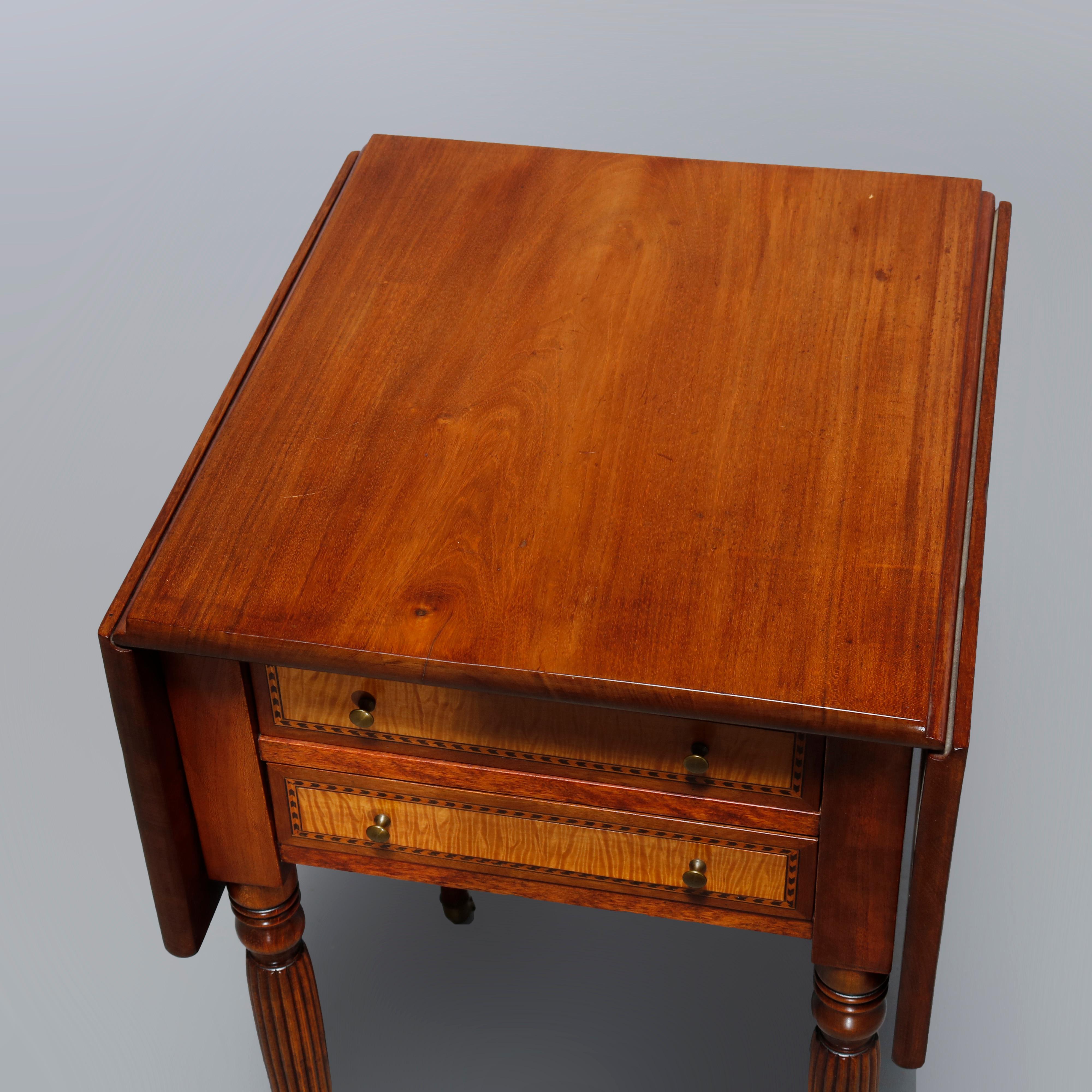 An antique Sheraton side stand offers cherry and tiger maple construction with top having drop leaves over double drawer case and raised on tapered and reeded legs with casters, c1830

Measures: 28.25