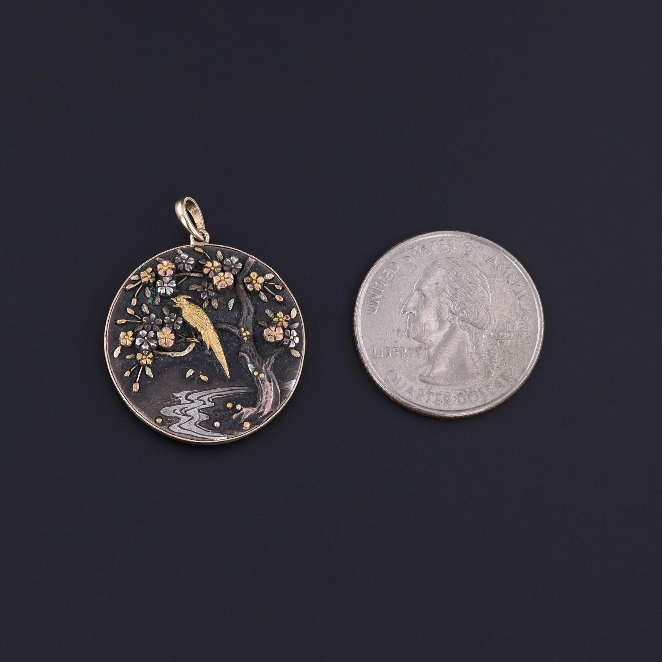 Antique Shibuichi Pendant: This pendant features a three dimensional scene of a bird in a blossoming tree. The pendant is a Japanese mixed metal technique known as shibuchi (similar to shakudo). It was originally an antique cufflink (circa