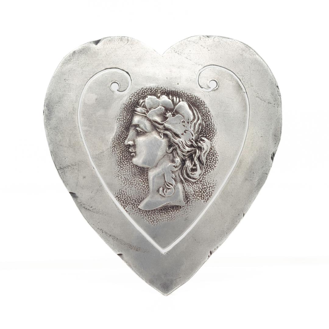A fine antique Shiebler Etruscan Revival bookmark.

In sterling silver.

In the form of a heart with a cameo profile of a woman to the center.

Simply a wonderful Shiebler bookmark!

Date:
Late 19th or Early 20th Century

Overall Condition:
It is in