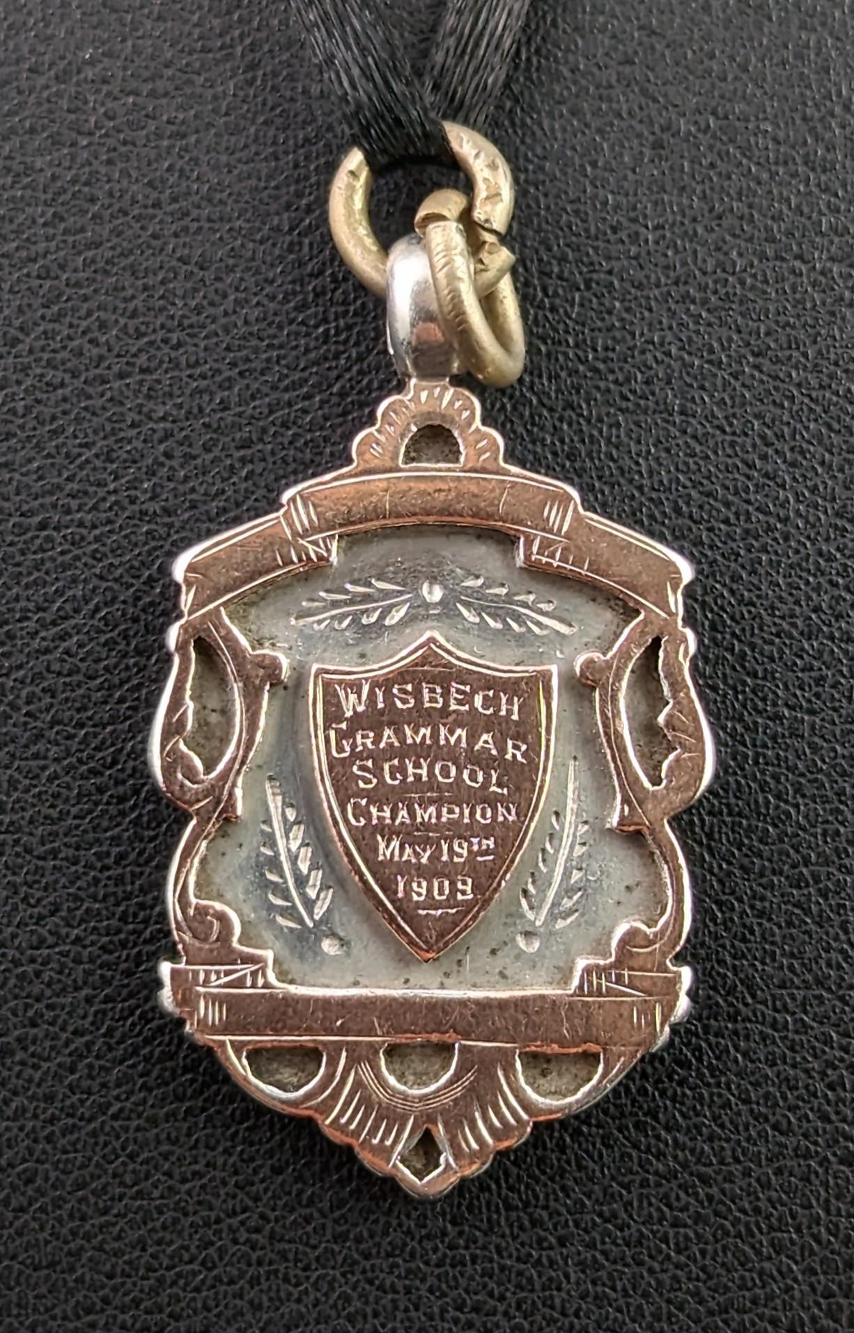 An attractive antique, Edwardian sterling silver and Rose gold shield fob.

A nice heavy fob with a decorative shield shaped design and a 9kt Rose gold cartouche to the centre, this has been monogrammed on both sides for Wisbech Grammar School,