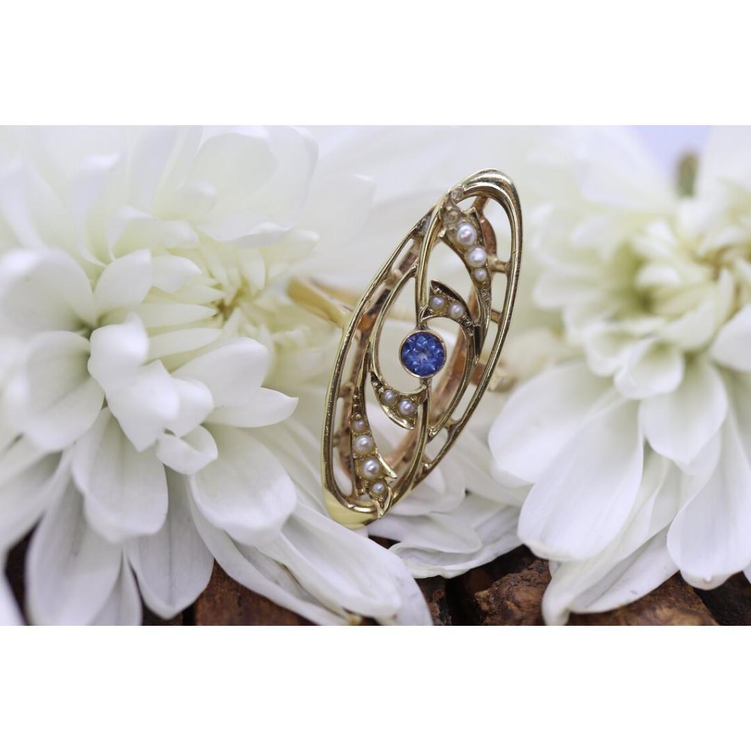 Vintage from the 1950s
Size: 8 US
Materials: Gold
Gemstone: Sapphire
Gem color: Colorless
Band color: Gold

Style: Art deco

Very beautiful Art Deco pearl seed and sapphire ring. Filigree open design shield with center sapphire and pearl seeds set