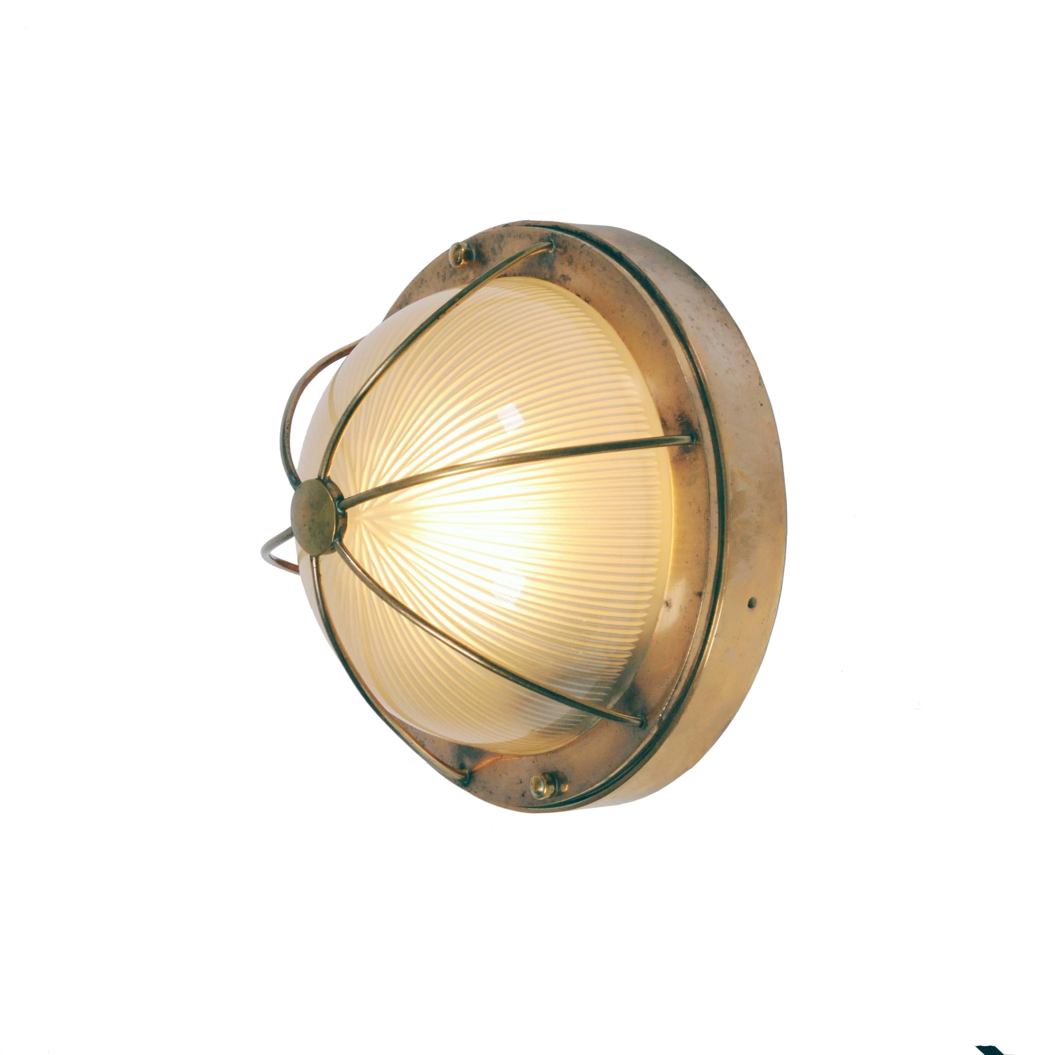 A rare ship liner ceiling or wall light with a striking quality prismatic glass dome made by Holophane. The glass shade is protected by a beautiful brass cage. The quality of the Holophane glass shade is like crystal clear and enables the perfect