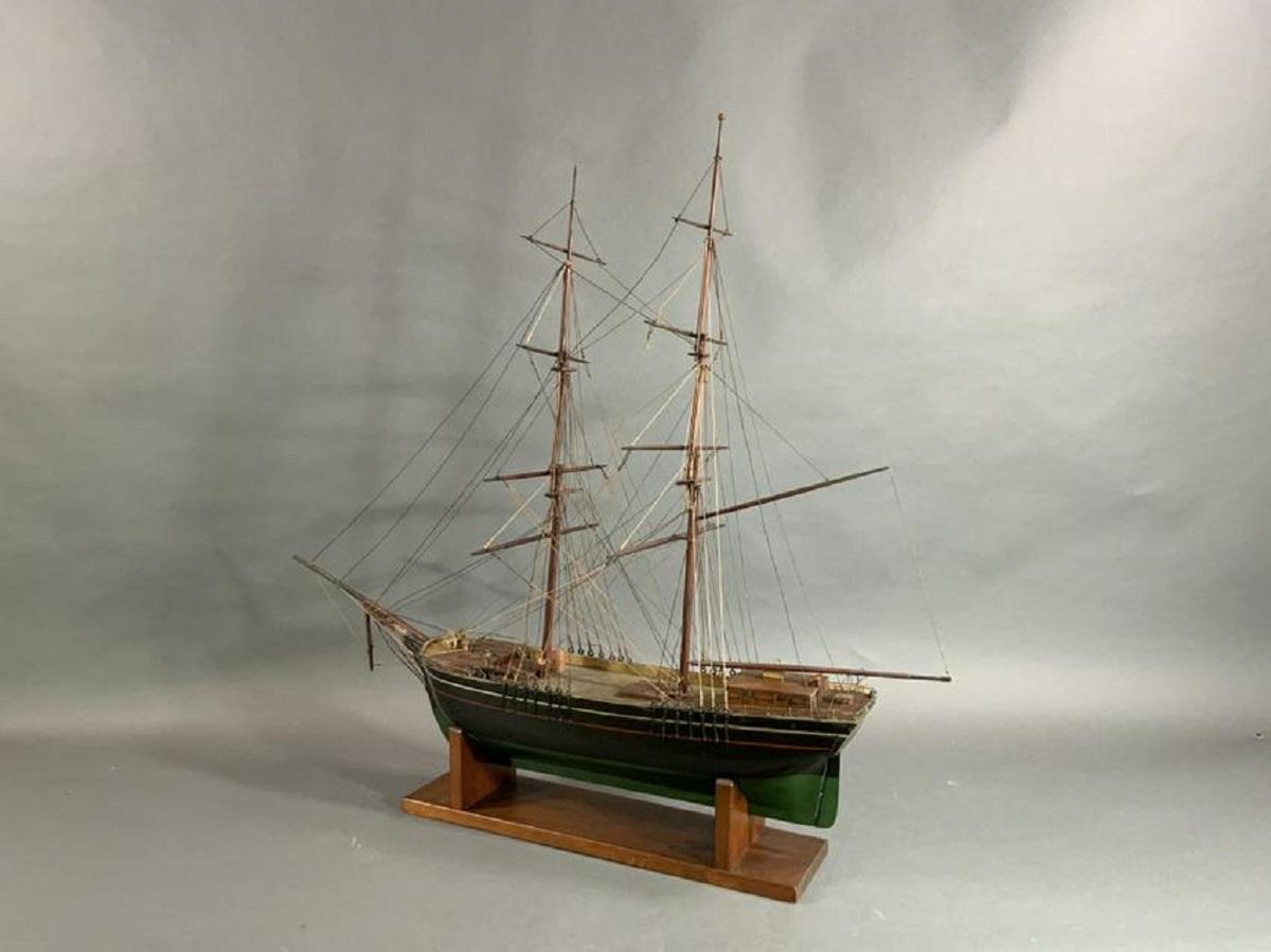 Nineteenth century ship model. Nicely proportioned hull with black over green paint and a red and cream stripe. Lifeboat hangs from a davit. Varnished masts. Wood cradle.

Overall dimensions: Weight is 7 pounds. 36