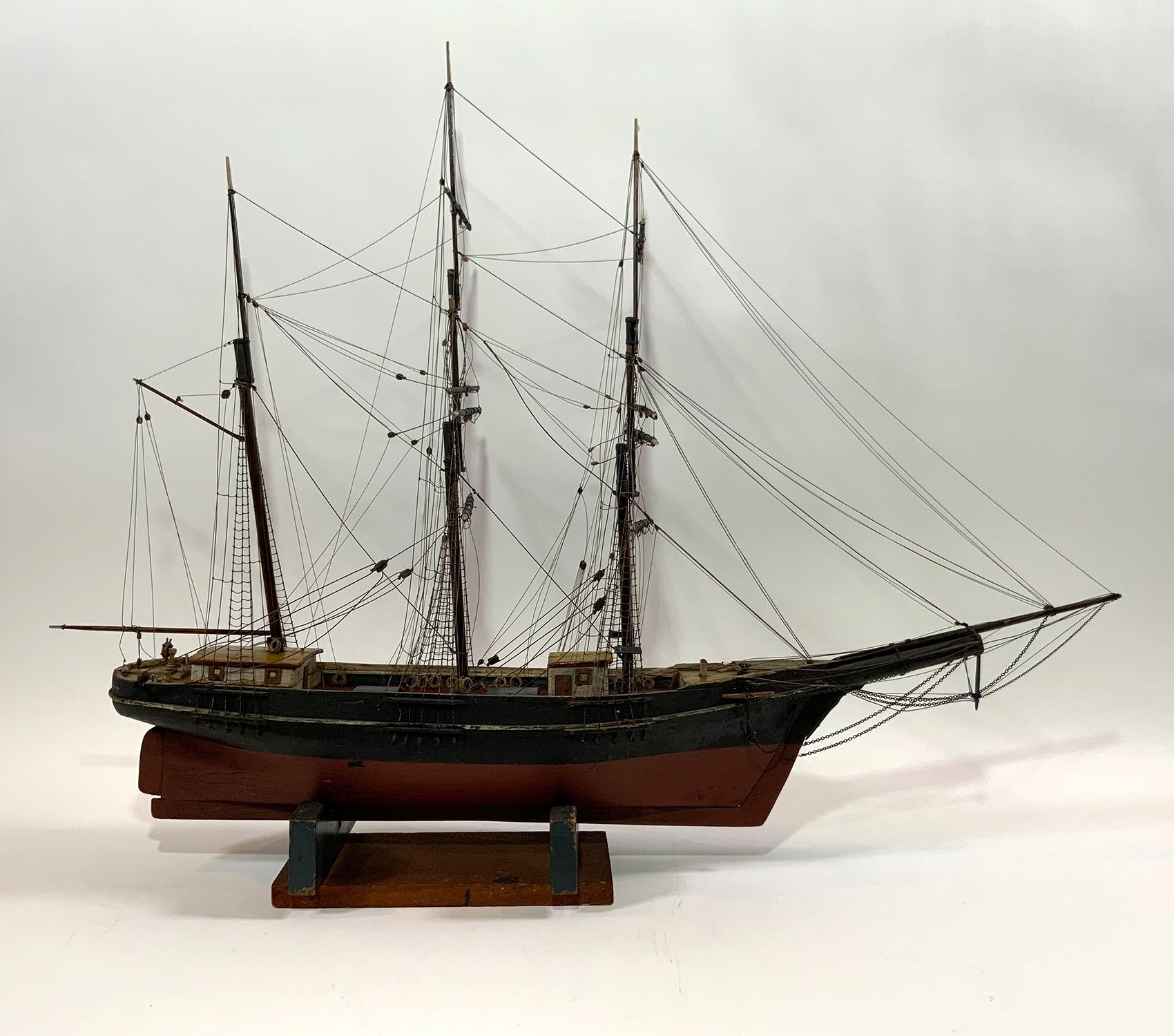 This antique rigged model has standing and running cords, cabins, hatches, etc., colorful paint job. Great old mustard paint. Set onto a simple cradle. Identified on the stern as the T Remmick of Boston. 

Weight: 5 LBS
Overall dimensions: 29” H