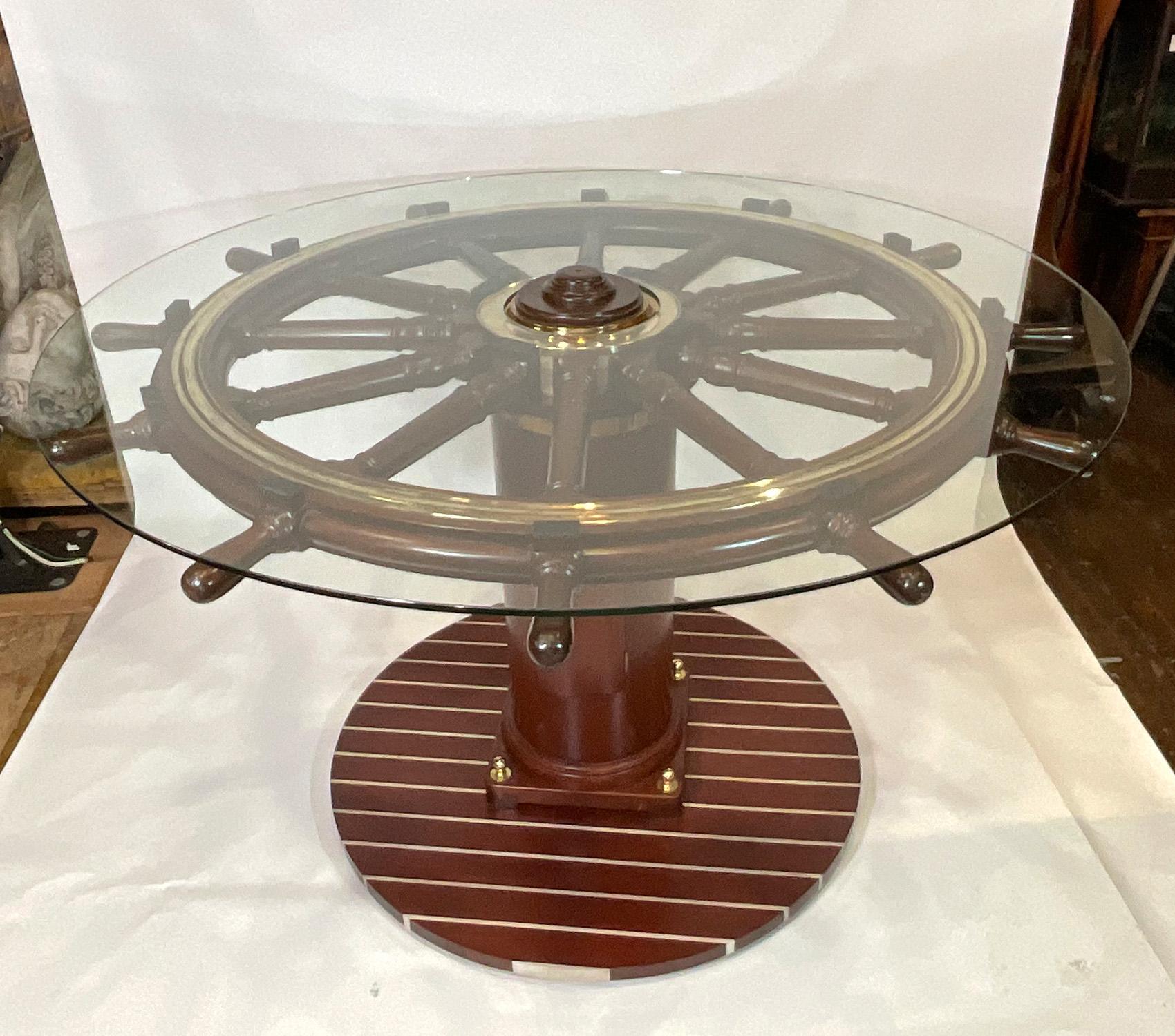 Outstanding antique ships wheel that has been mounted onto. turned spindles, solid brass hub with a thick wood base in the form of ships decking. The wheel has been meticulously restored. The wheel has twelve turned spindles. Solid brass hub with