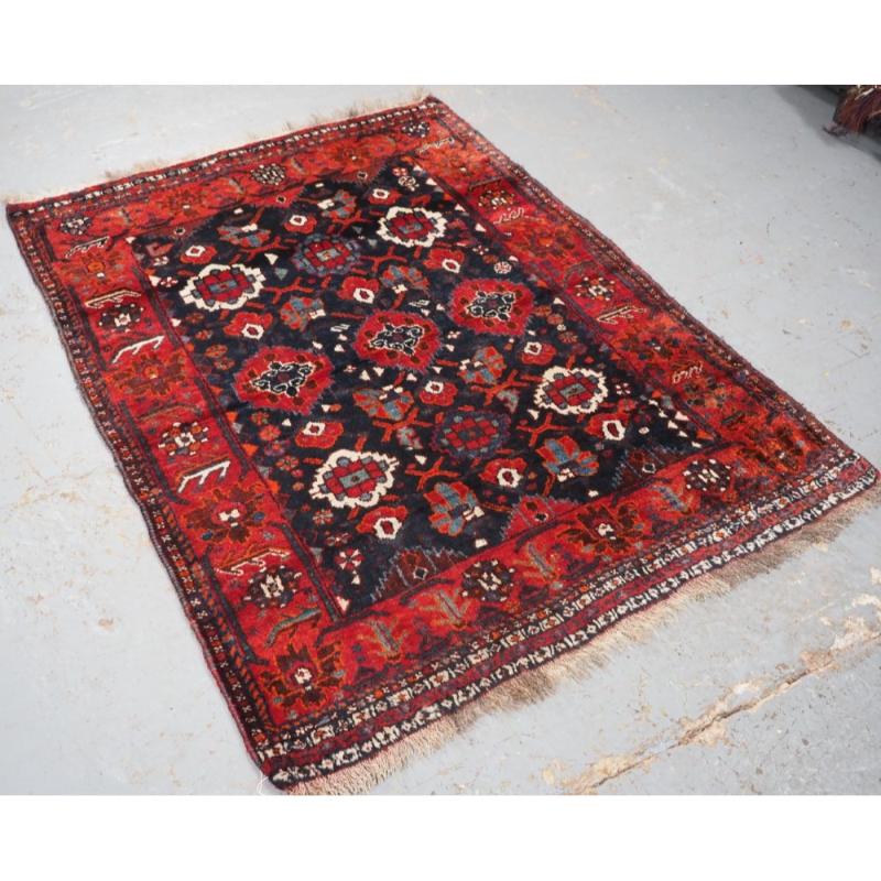 Antiker Teppich mit Stammesmuster aus der Region Shiraz, wahrscheinlich von sesshaften Knüpfern des Khamseh- oder Qashqai-Stammes
CIRCA 1920

Ein guter Teppich hat ein sich wiederholendes florales Rosettenmuster, der Teppich enthält viele