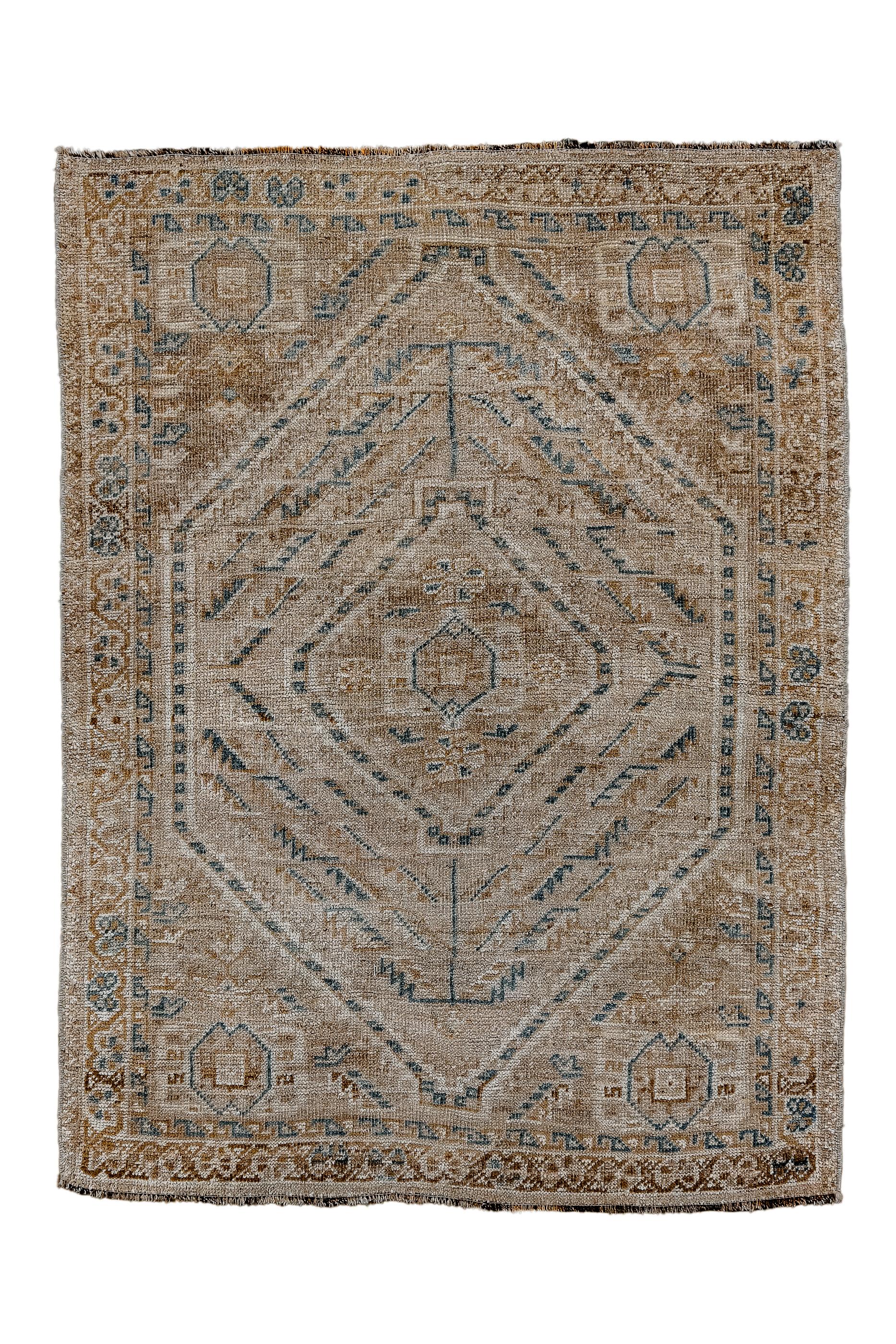 The rust corners with simplified south Persian tribal medallions set off the brown hexagonal field with a central device repeating those of the corners, and a triple wreath of serrated, oblique leaves.  The dark sections of the leaves create a sense
