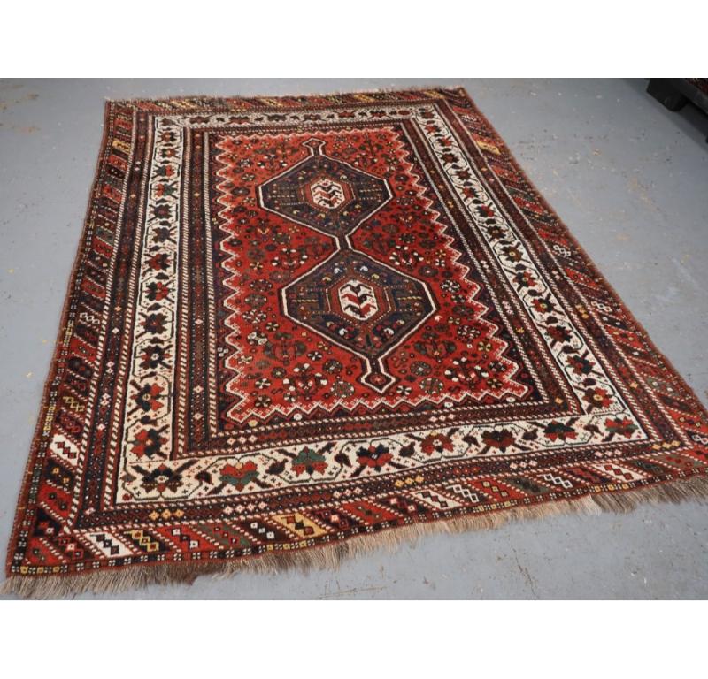 Tapis tribal ancien de la région de Shiraz, probablement réalisé par des tisserands sédentaires de la tribu Khamseh.
Circa 1920

Un bon tapis de forme carrée avec un motif de médaillon lié encadré par une bordure principale sur fond ivoire avec une