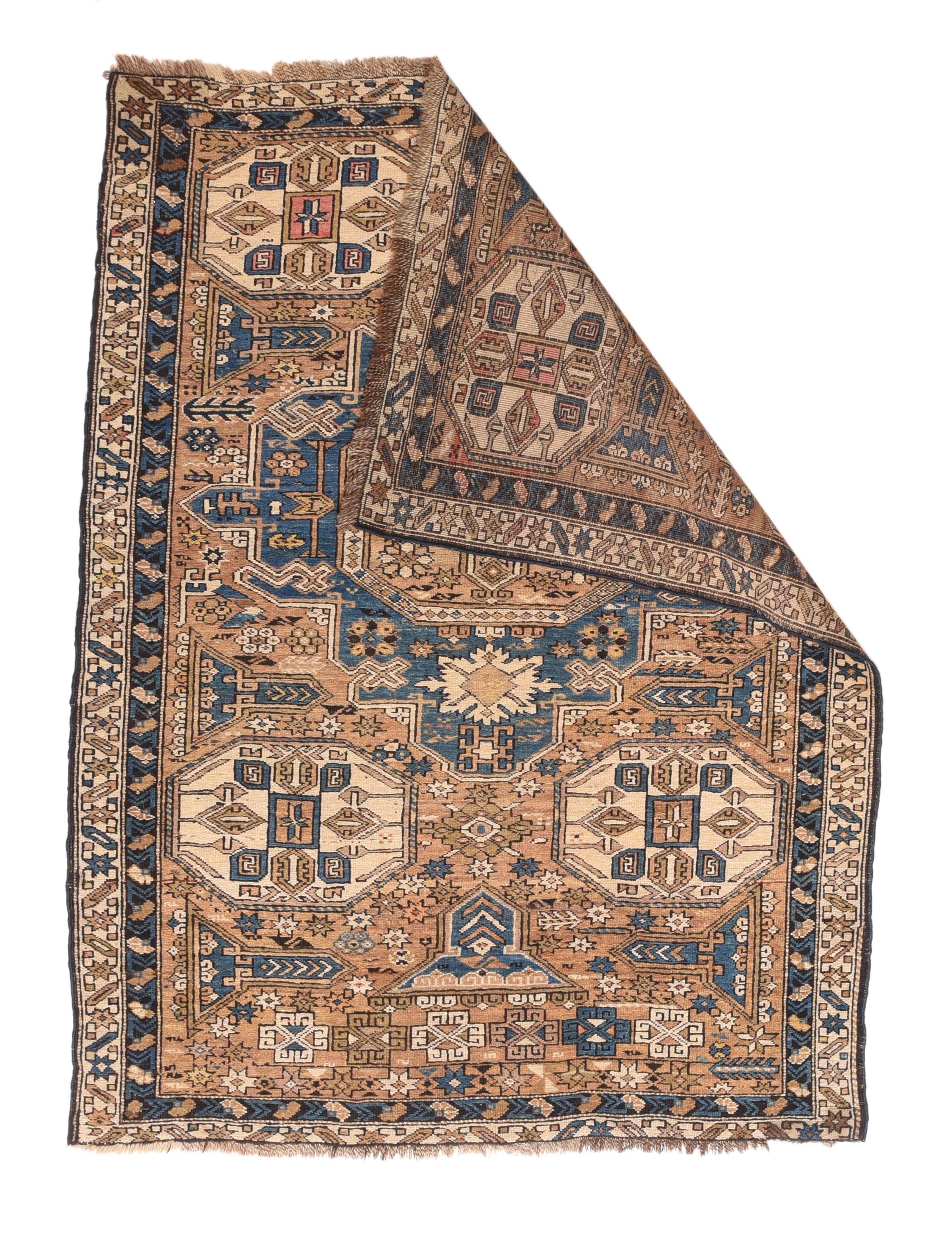 Adapted from a flatwoven Soumak rug design, this east Caucasian scatter shows a single reticulated medium blue faceted cruciform medallion with four pale straw secondary octagons and lateral; “rocket ships” on a dusty rose field. A row of squared