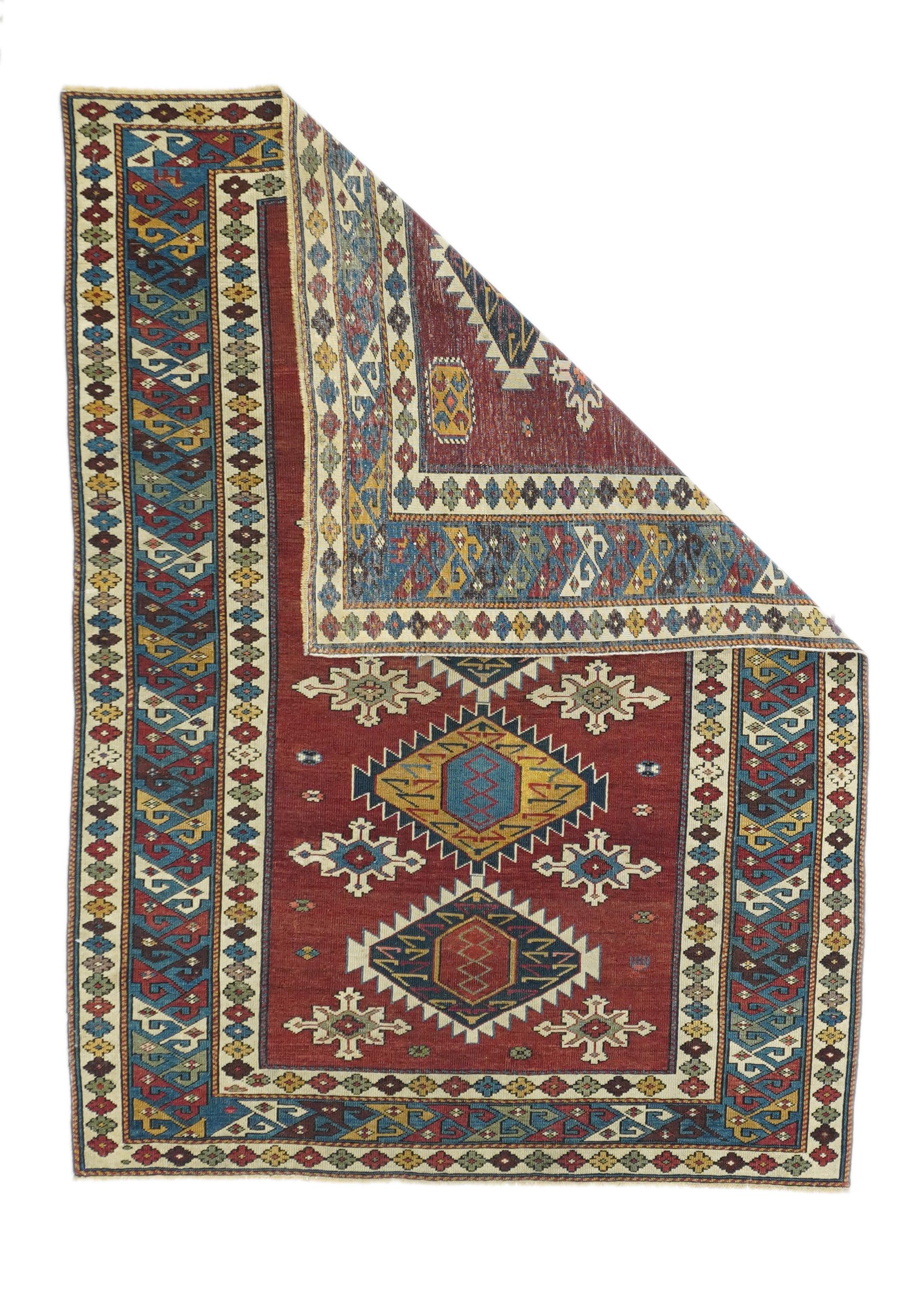 Antique Shirvan rug 3'8'' x 5'2''. The dark red field displays five deeply serrated stacked lozenges in old gold, ecru, teal blue, charcoal and red, with ivory supporting stars. Teal blue border of wedge 