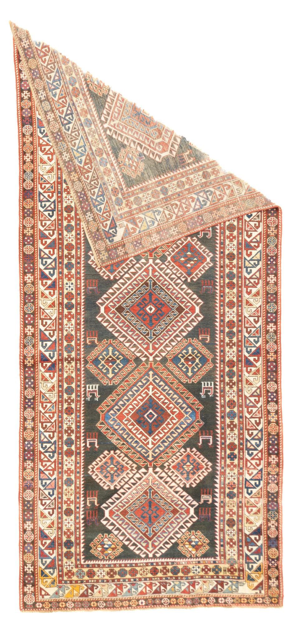 Tapis Shirvan antique 4' x 9'. Le champ olive foncé présente un vaste médaillon polaire composé de cinq diamants superposés et densément crochetés, avec de petits animaux latéraux de soutien. Bordure principale écrue du triangle : 