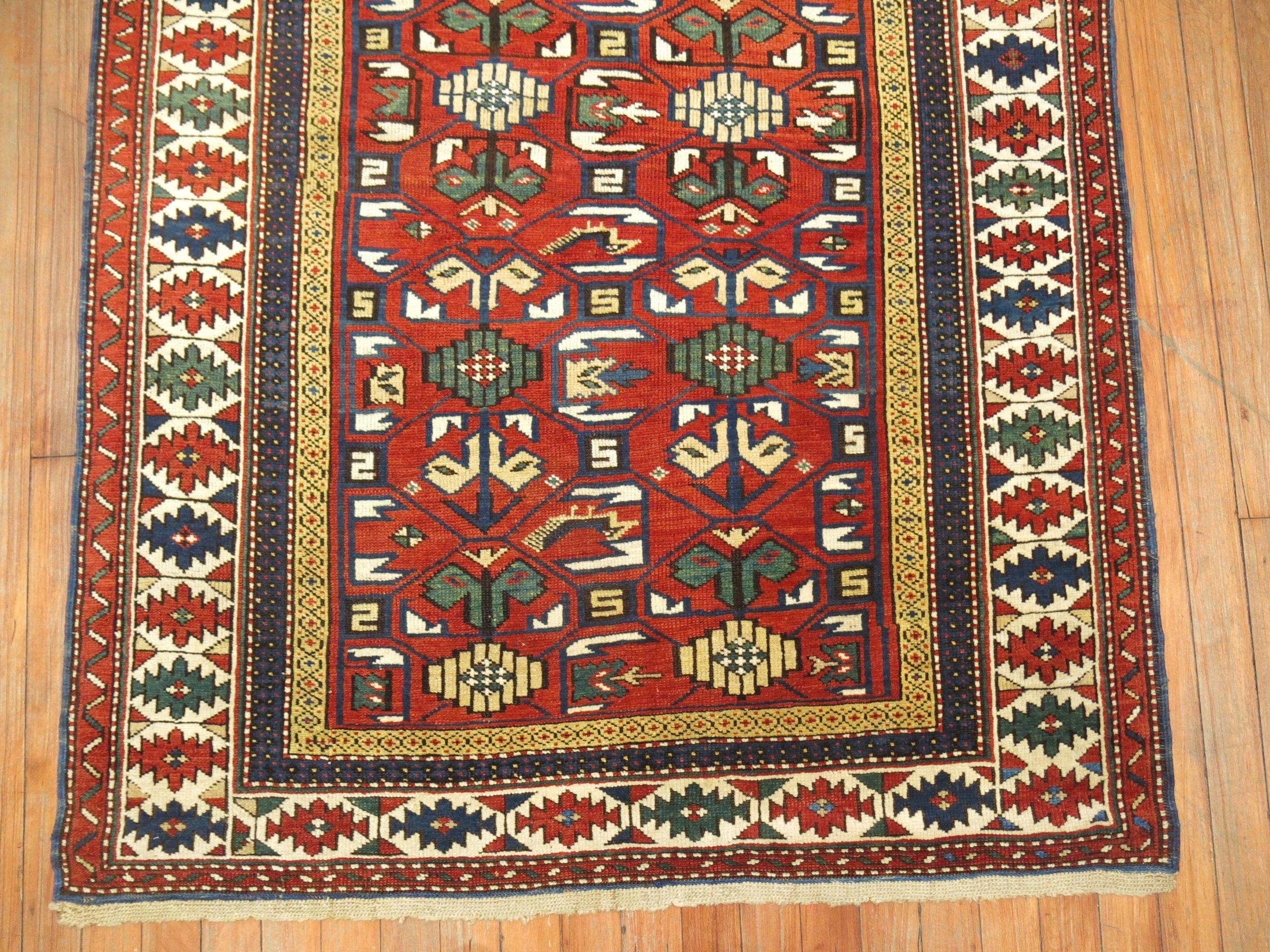 A geometric tribal looking Caucasian Shirvan rug from the early 20th century.
accents in blue, green, yellow on a red ground. The border is ivory

Measures: 3'7