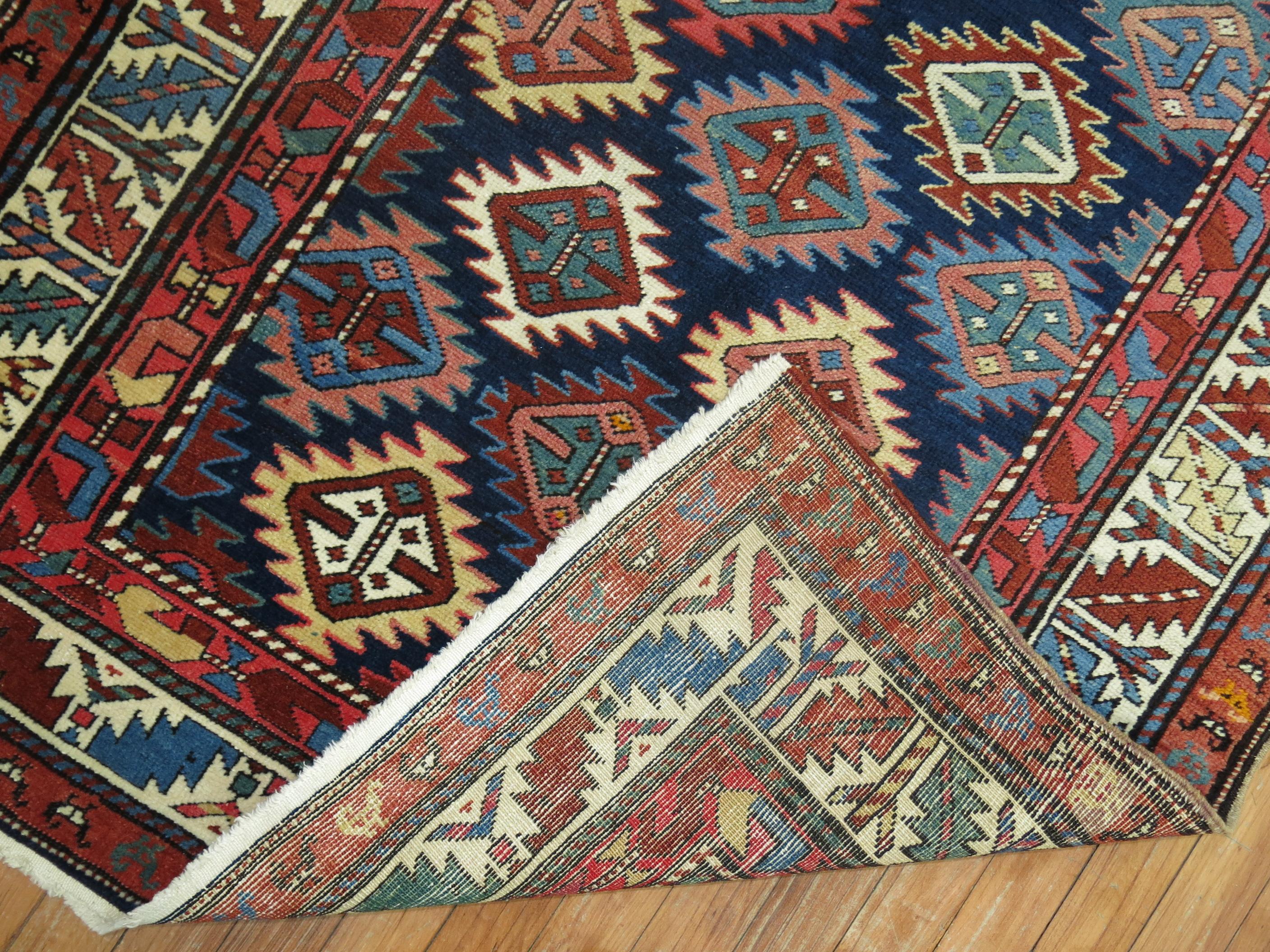 A geometric tribal looking Caucasian Shirvan rug from the early 20th century. Colorful geometric design on a navy blue field.

Antique Caucasian rugs from the Shirvan district village are still considered one of the best decorative and collector