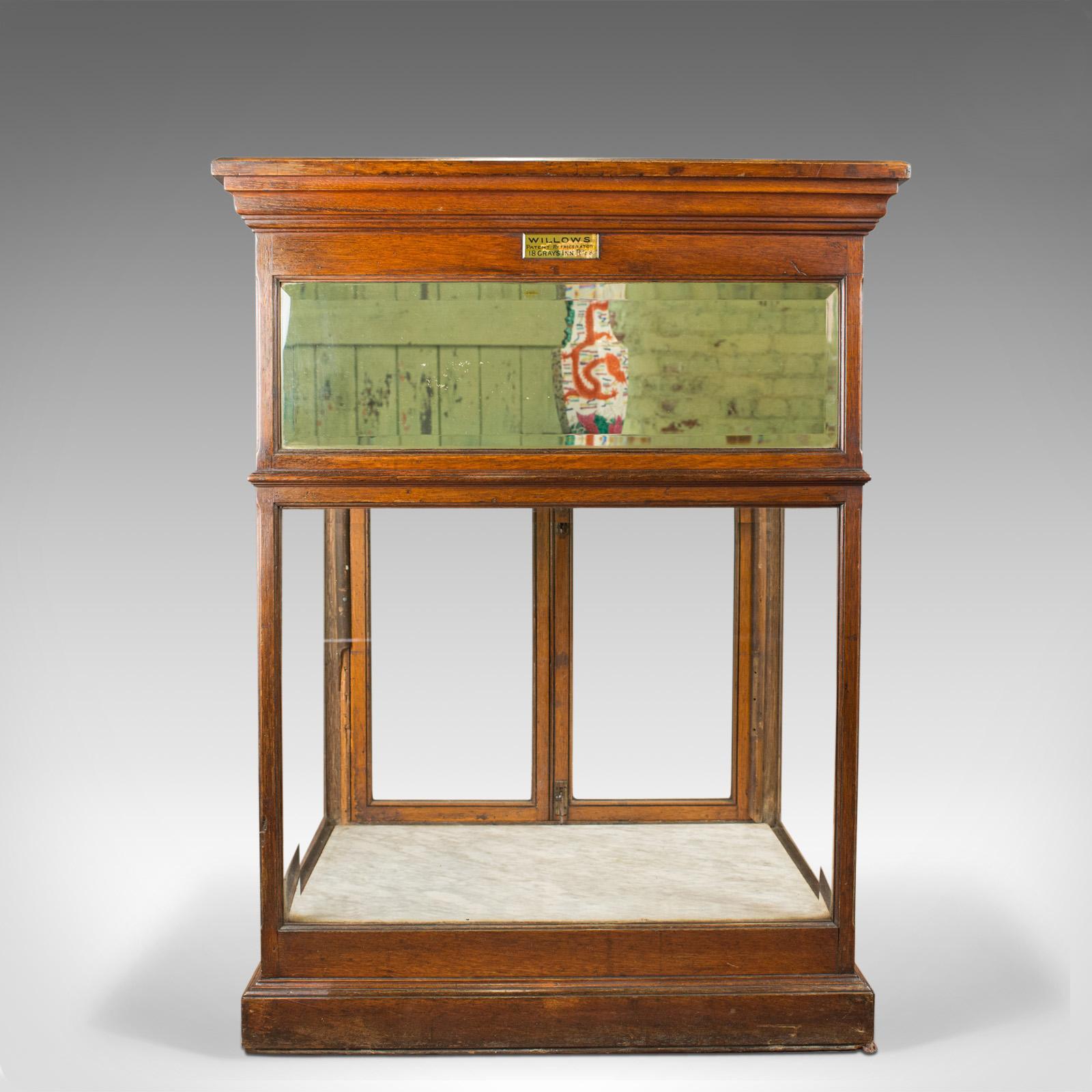 This is an antique shop display cabinet, crafted in England by Edward Willows from mahogany, glass and marble. First patented in the late 19th century, this improved model dates to circa 1905.

Of quality craftsmanship in mahogany, displaying a