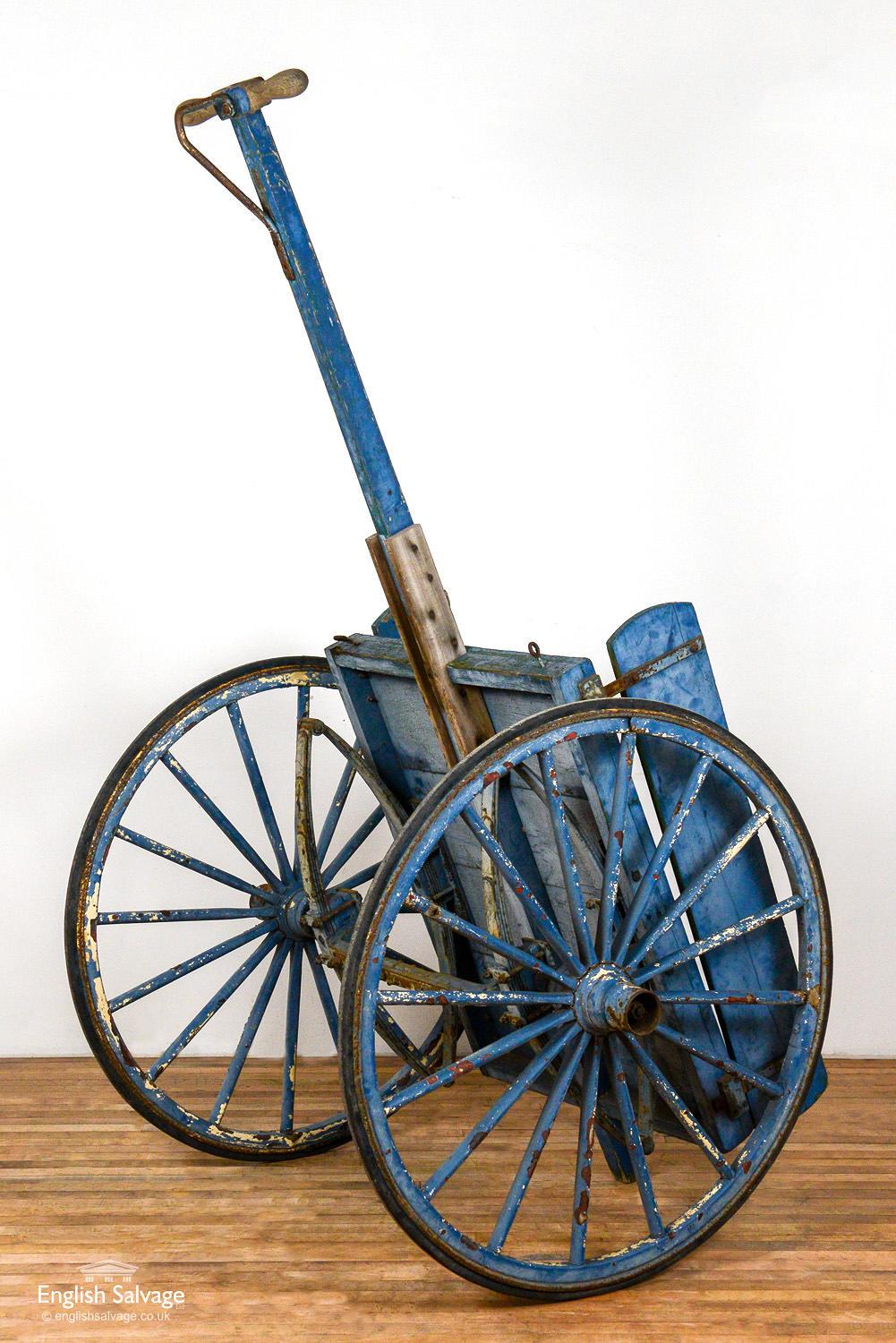 Original salvaged shop mongers cart / barrow with old distressed blue paint. Hard rubber wheel rims and wrought iron chassis. Good overall condition with some splits and dings to the wood. Cart bed area of 83cm wide x 107cm deep.