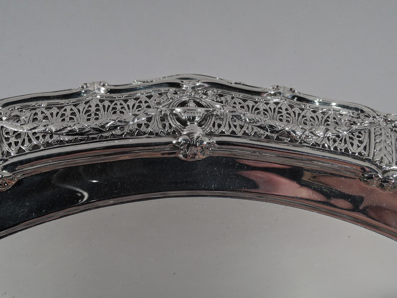 Edwardian Regency sterling silver tray in Adam. Made by Shreve & Co. in San Francisco, circa 1910. Plain well and wide shoulder with classical vases overlapping rondels joined by leaf swags on pierced fern ground. Ogee scroll rim. Fully marked and