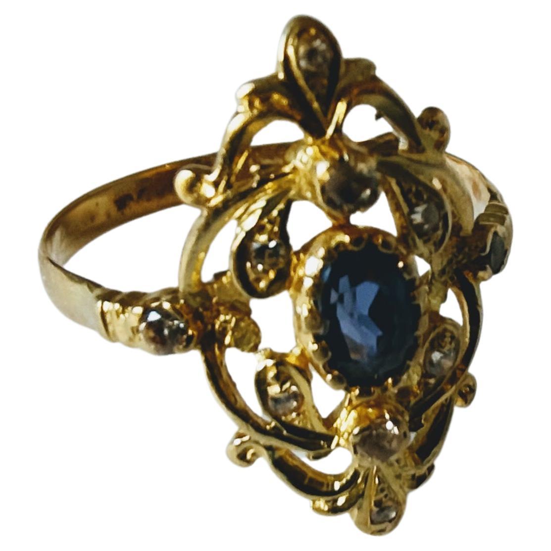 Antique and original ring of the early 20th century in the form of a shuttle with plant motifs in low relief, make of yellow gold 18 Karats weight 3.22 grams with central sapphire  oval shape measure 6.8x 5x 3.4 millimeters and 10 Diamonds of 1.3 to