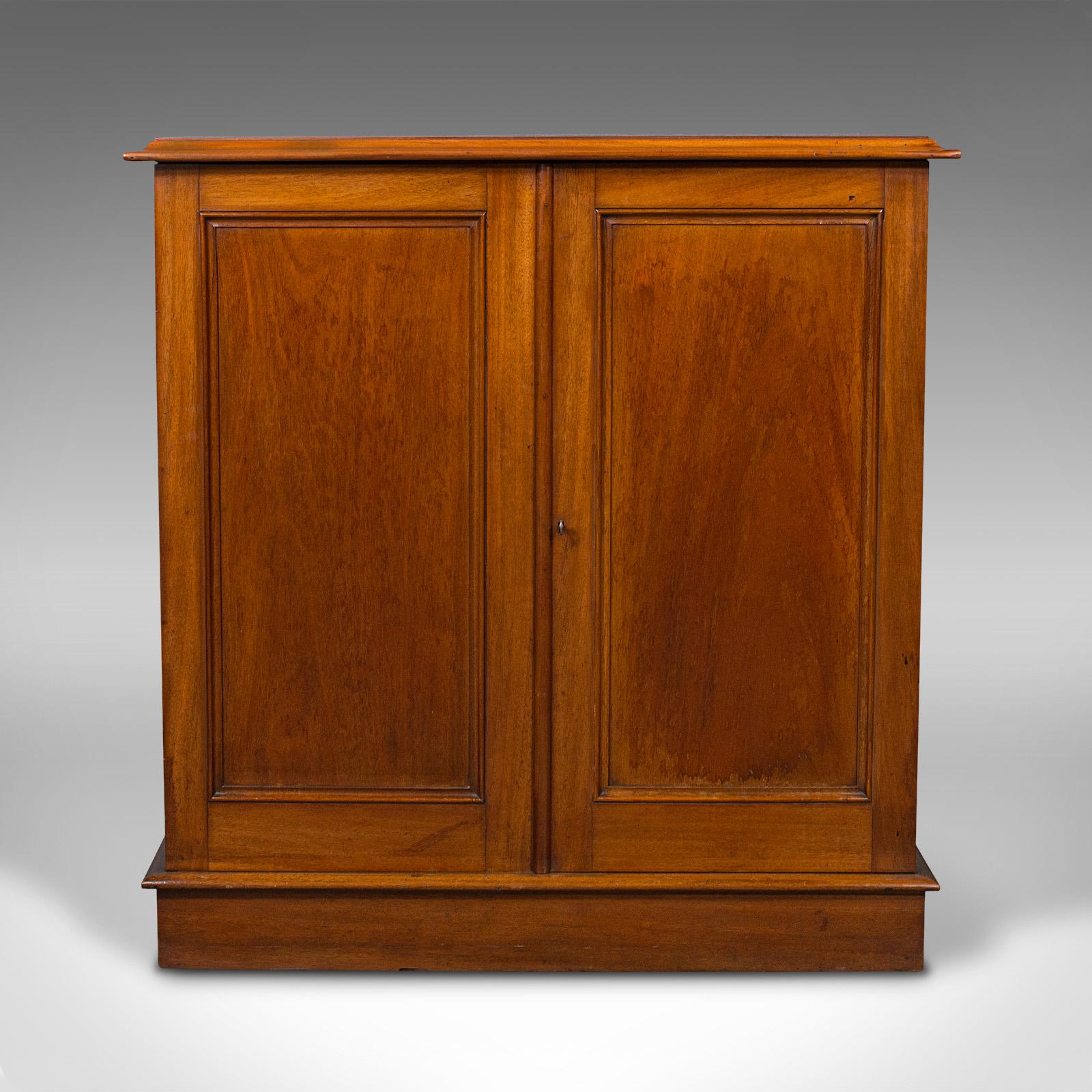 This is an antique side cabinet. An English, mahogany enclosed bookshelf or drinks cupboard, dating to the mid Victorian period, circa 1860.

Delightfully presented cabinet, with a usefully shallow proportion
Displays a desirable aged patina and