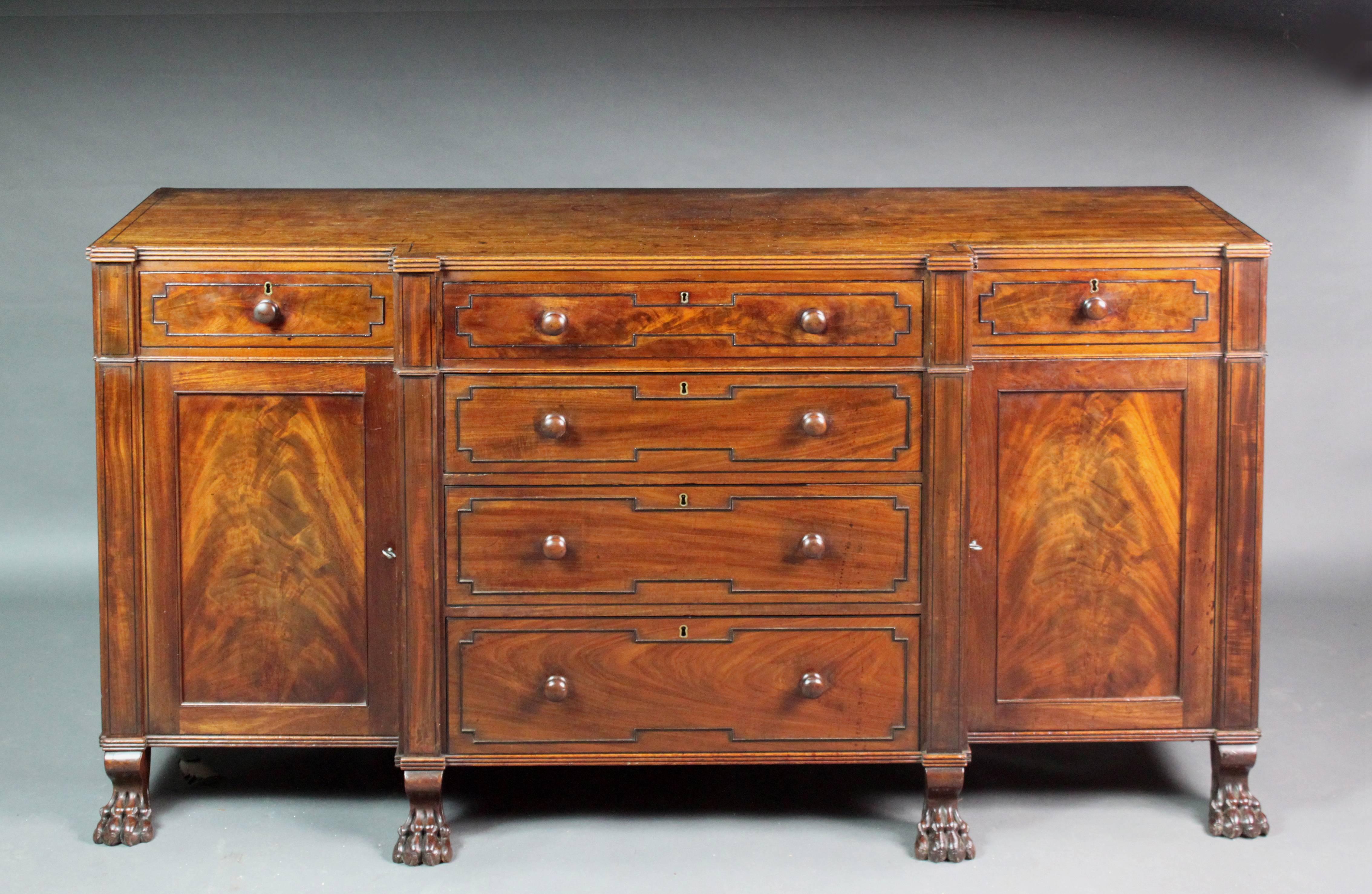 A George III break-front side cabinet in figured mahogany with ebony stringing and well-carved paw-feet; mahogany drawer sides with cedar wood bottoms. See photo of patch in top which is barely visible. Good color and patina.
