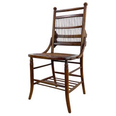 Silla auxiliar antigua con asiento de caña y respaldo de husillo