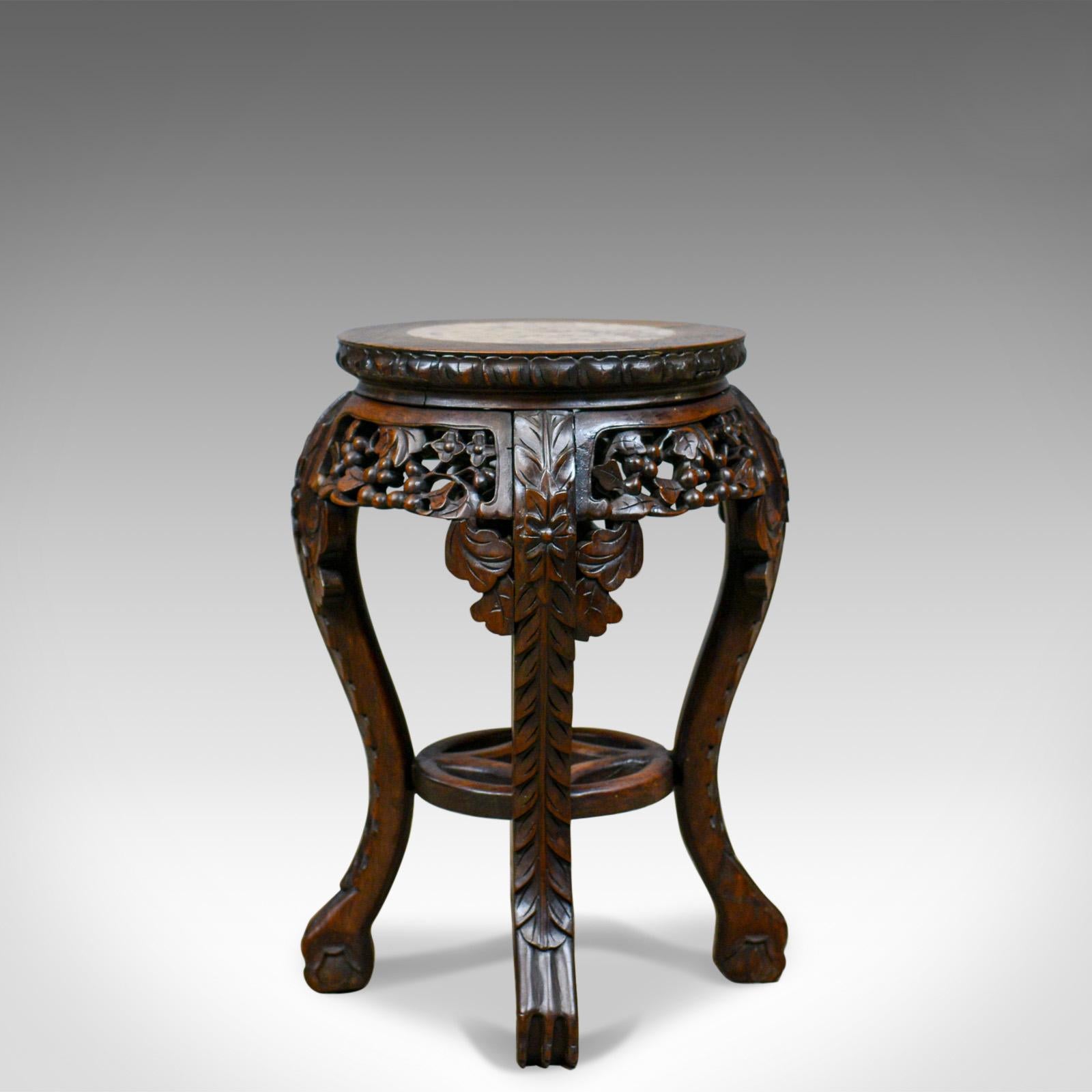 This is an antique side table, a carved Chinese stand in teak and marble, dating to the early 20th century, circa 1900.

Quality teak displaying good color and a desirable aged patina
Profusely carved with a dark, wax, polished finish
Classic