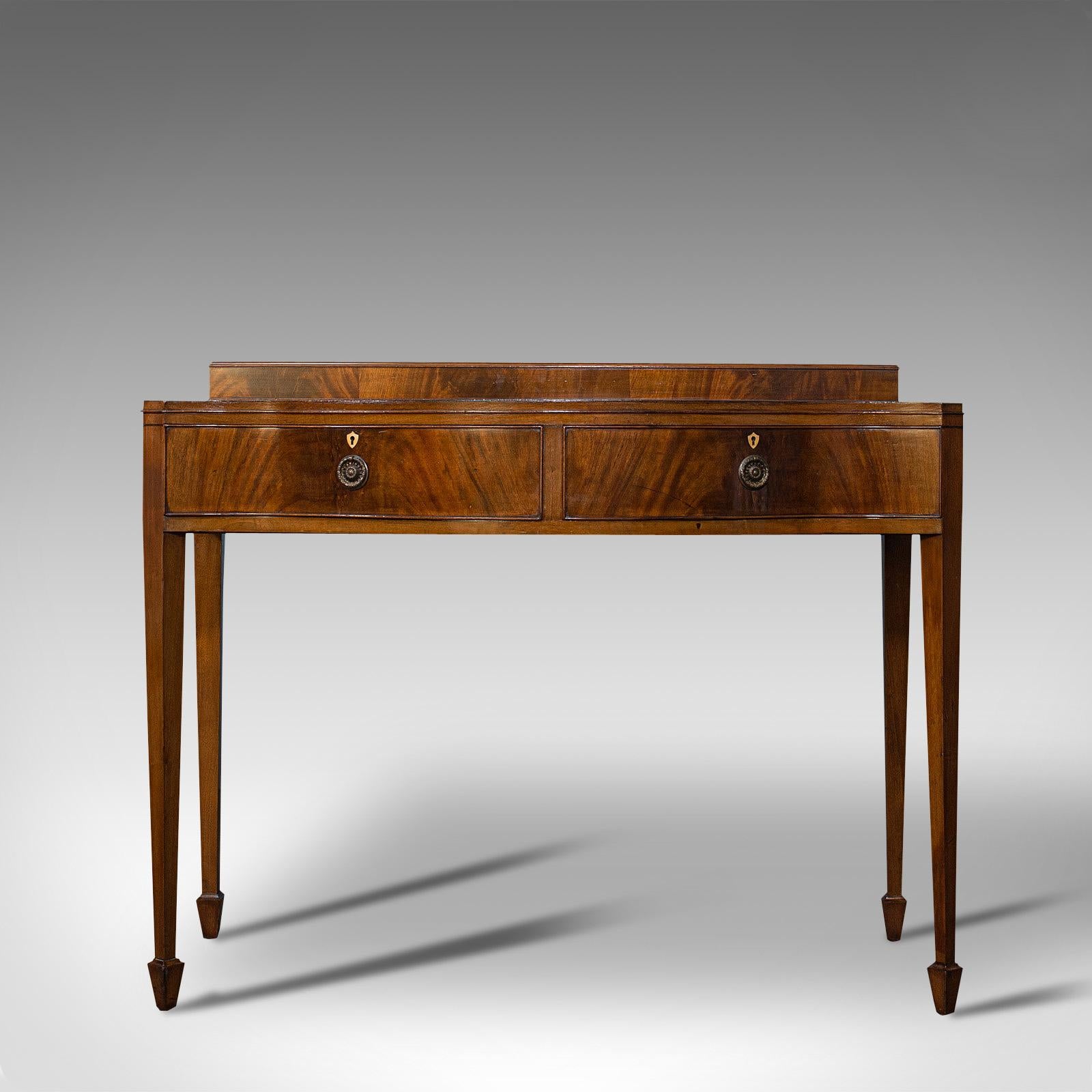 This is a superb antique side table. An English, mahogany buffet or server in the manner of Sheraton by Hamptons of London, dating to the Edwardian period, circa 1910.

Distinctive serpentine form with an abundance of quality
Displaying a