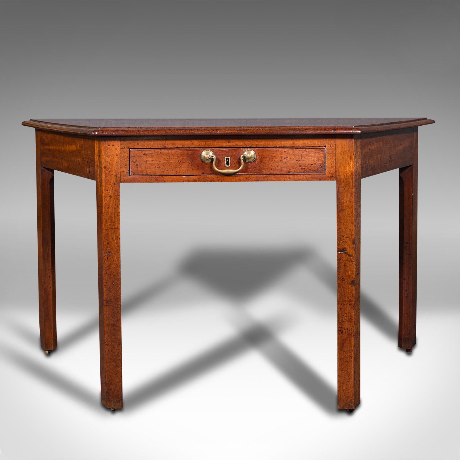 This is an antique side table. An English, mahogany writing desk, console or bay window table, dating to the Georgian period and later, circa 1800.

Distinctive side table with trapezoid from, ideal for bay window placement
Displays a desirable