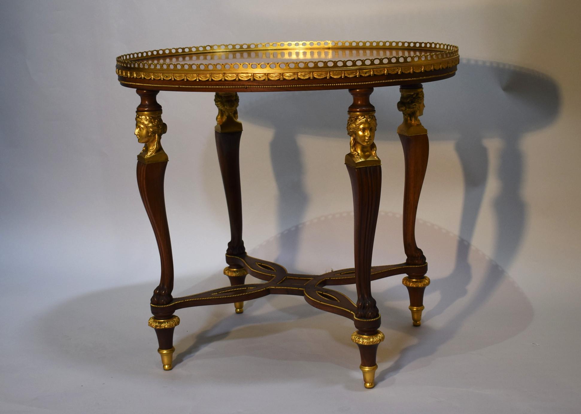 Superb oval shaped ormolu-mounted occasional table with pierced gallery and caryatid mounts on legs.