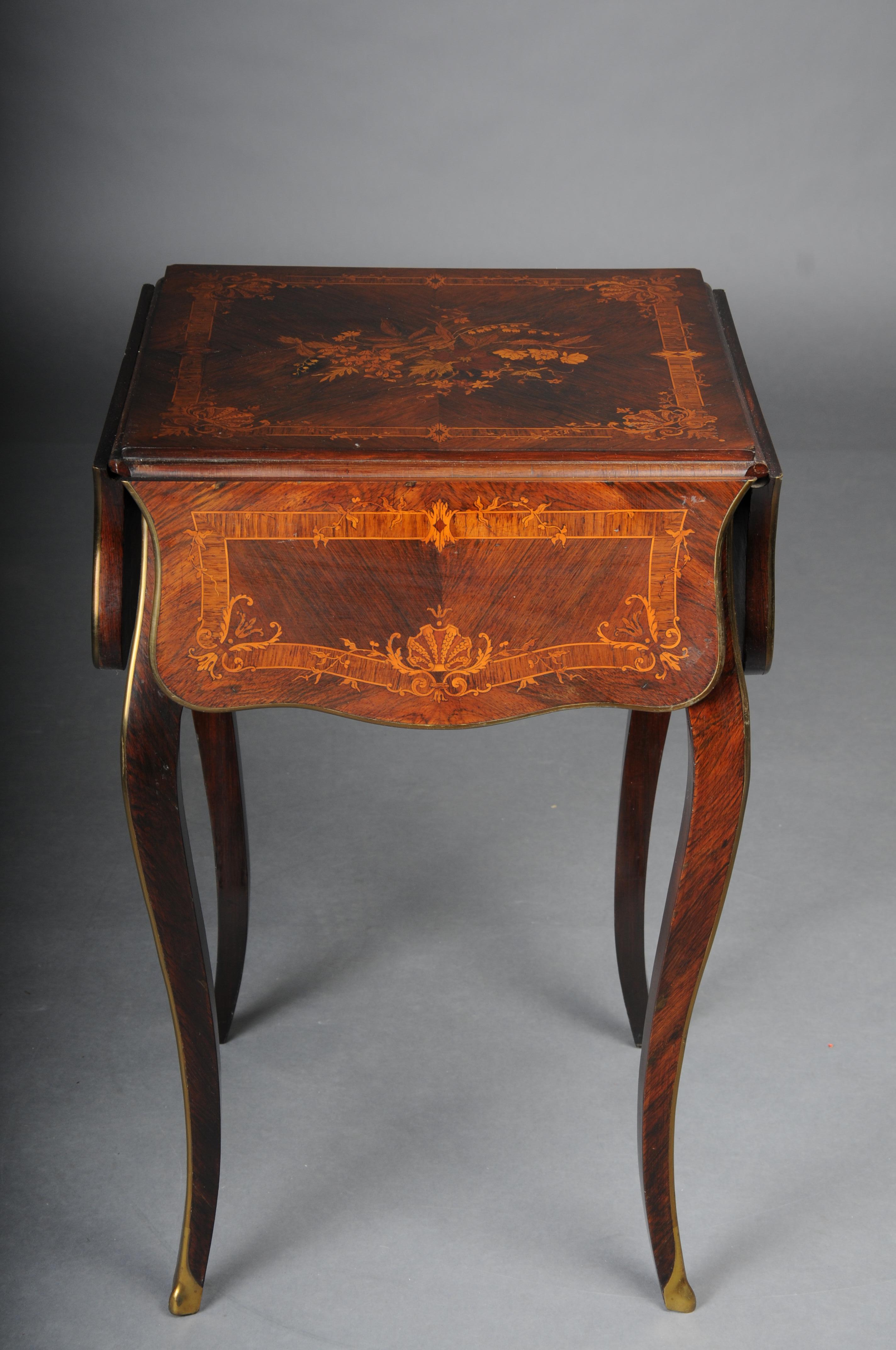 Antique side table, Paris around 1870 marquetry veneer.

Very highly finished inlaid folding side table with fine marquetry. Table edges refined with gold-plated brass strip.

The side table can be opened from any side and has a very useful and